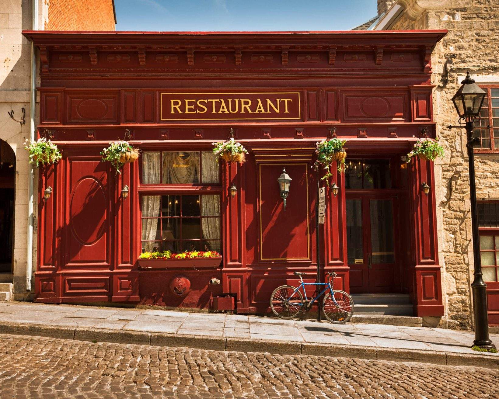 A classic French-style restaurant with a bicycle parked against the exterior wall.