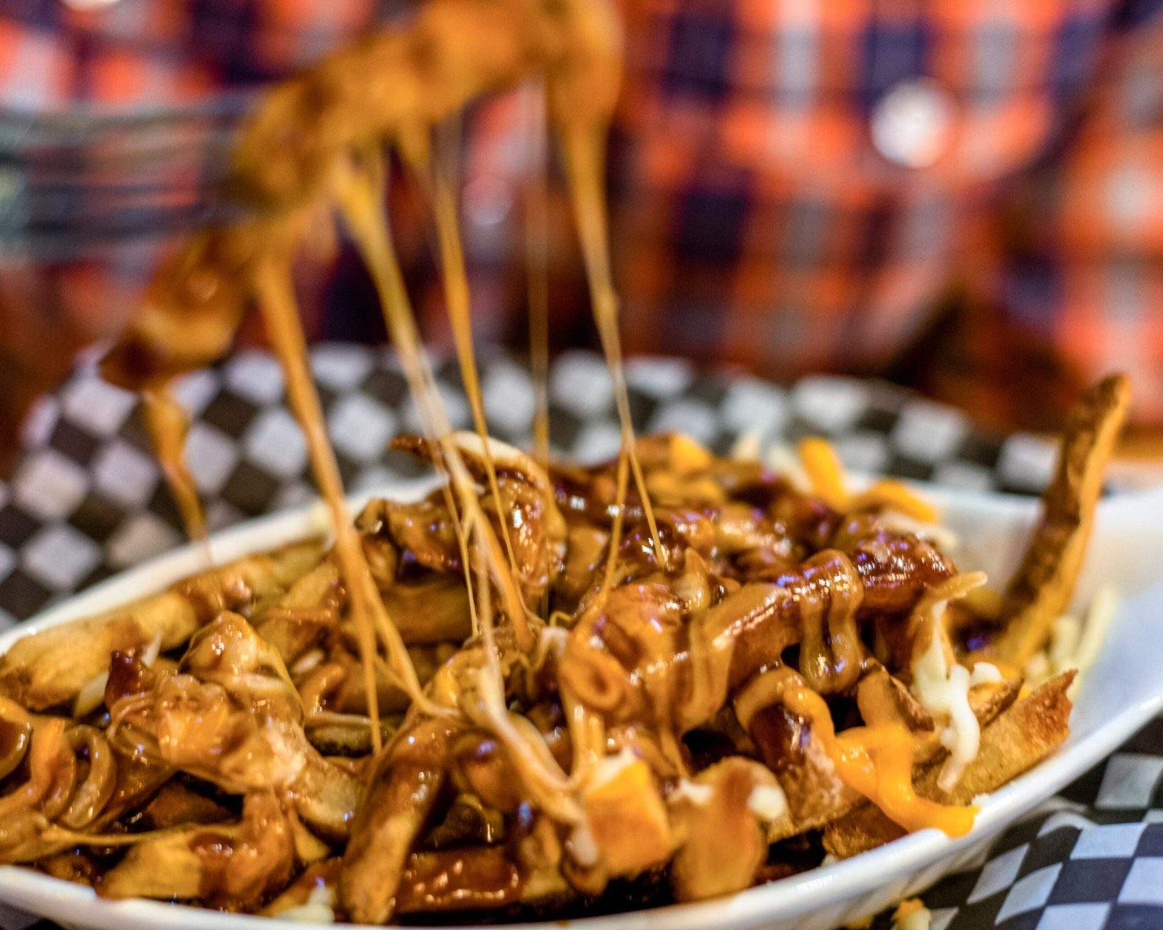 He picks up a cheesy bite with fork.