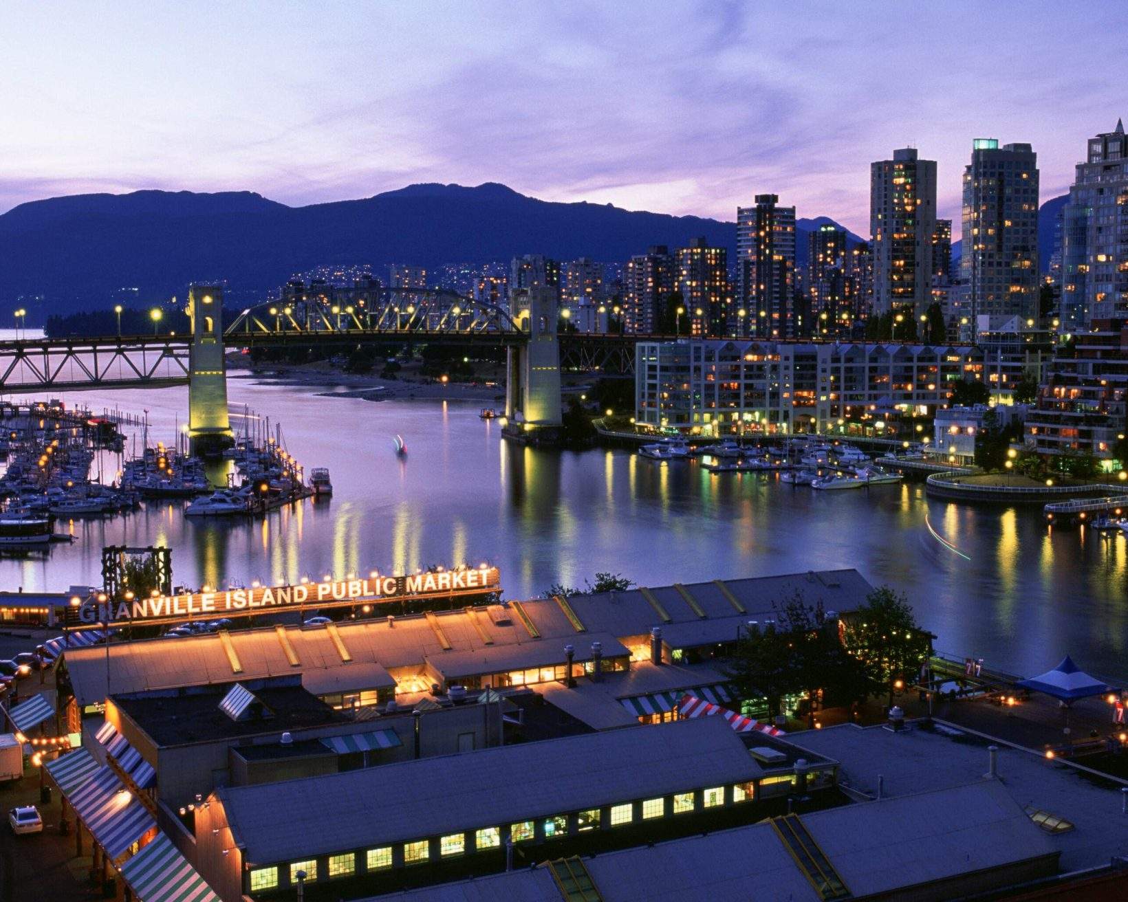 An Art Deco steel truss bridge crossing the False Creek provides access to the cityscape.