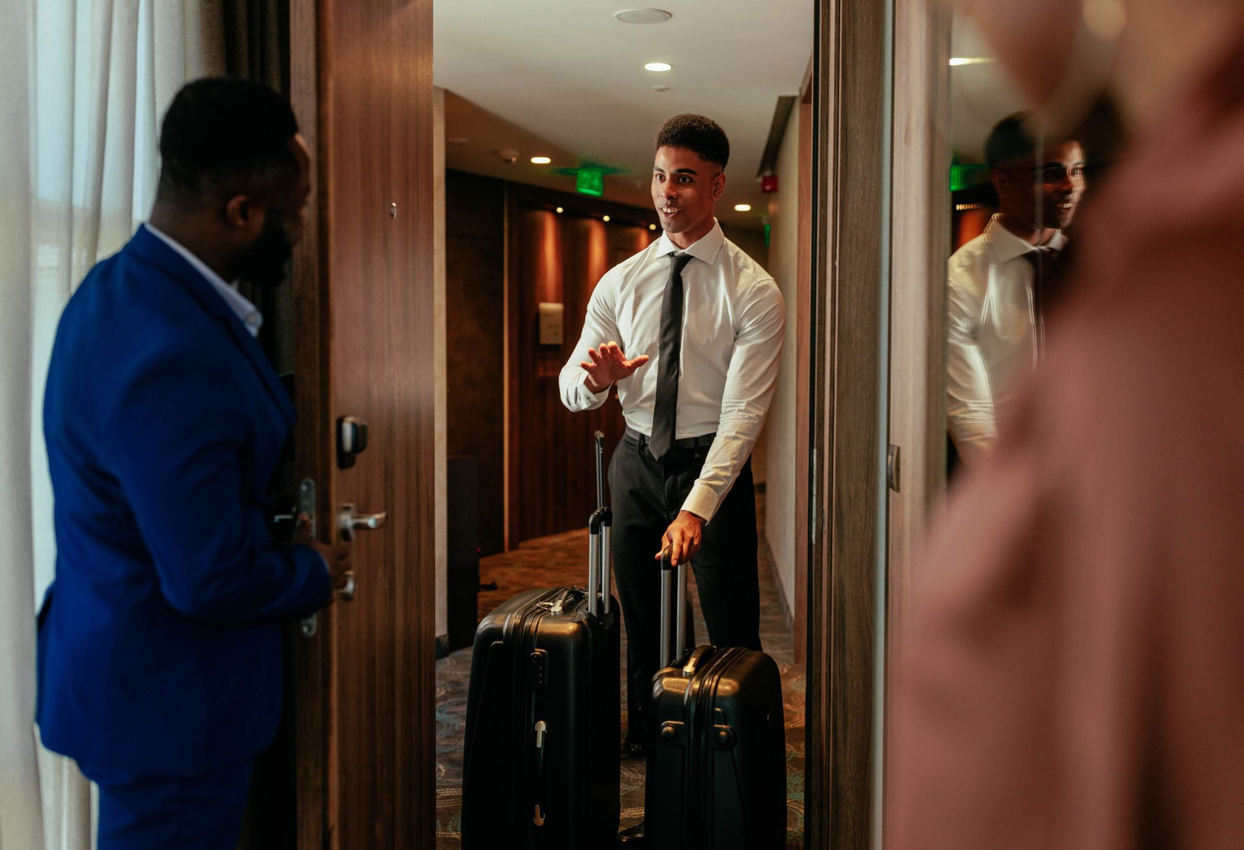 A young hotel attendant is delivering luggage to the hotels VIP guests in the presidential suite.