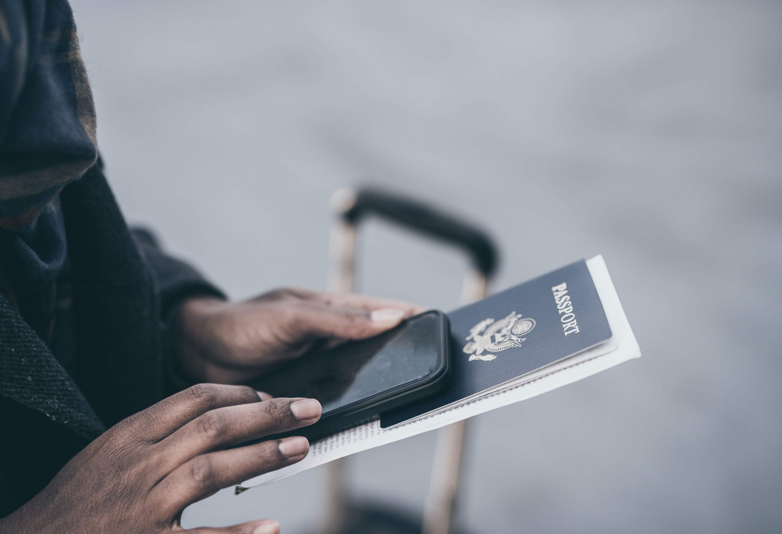 Young African American woman at airport holding passport.