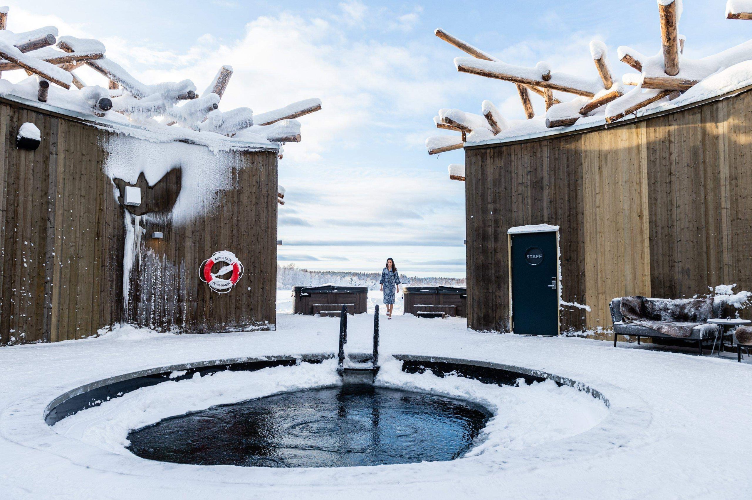 Exterior shot of the Arctic Bath Hotel. View of ice plunge pool surrounded by buildings during the day