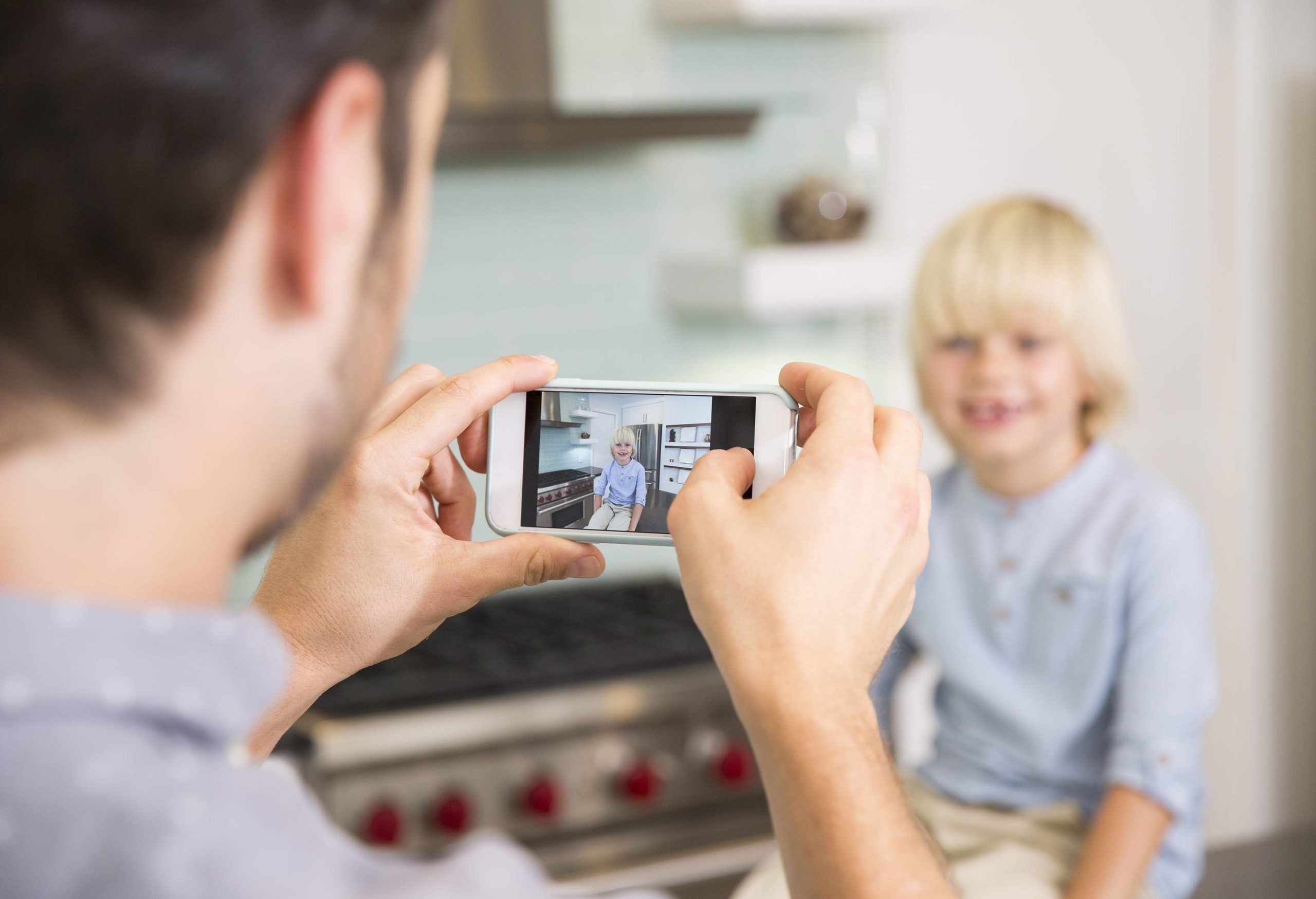 Father taking photo of child at home