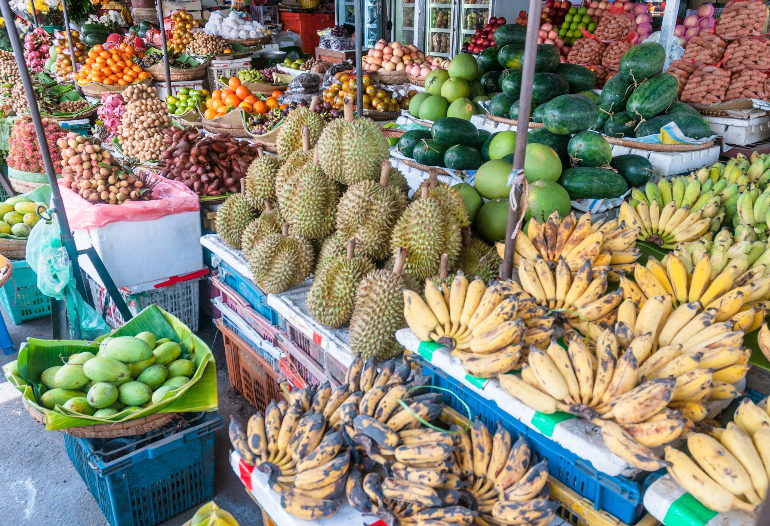 A fruit stand with a display of assorted colourful fruits.