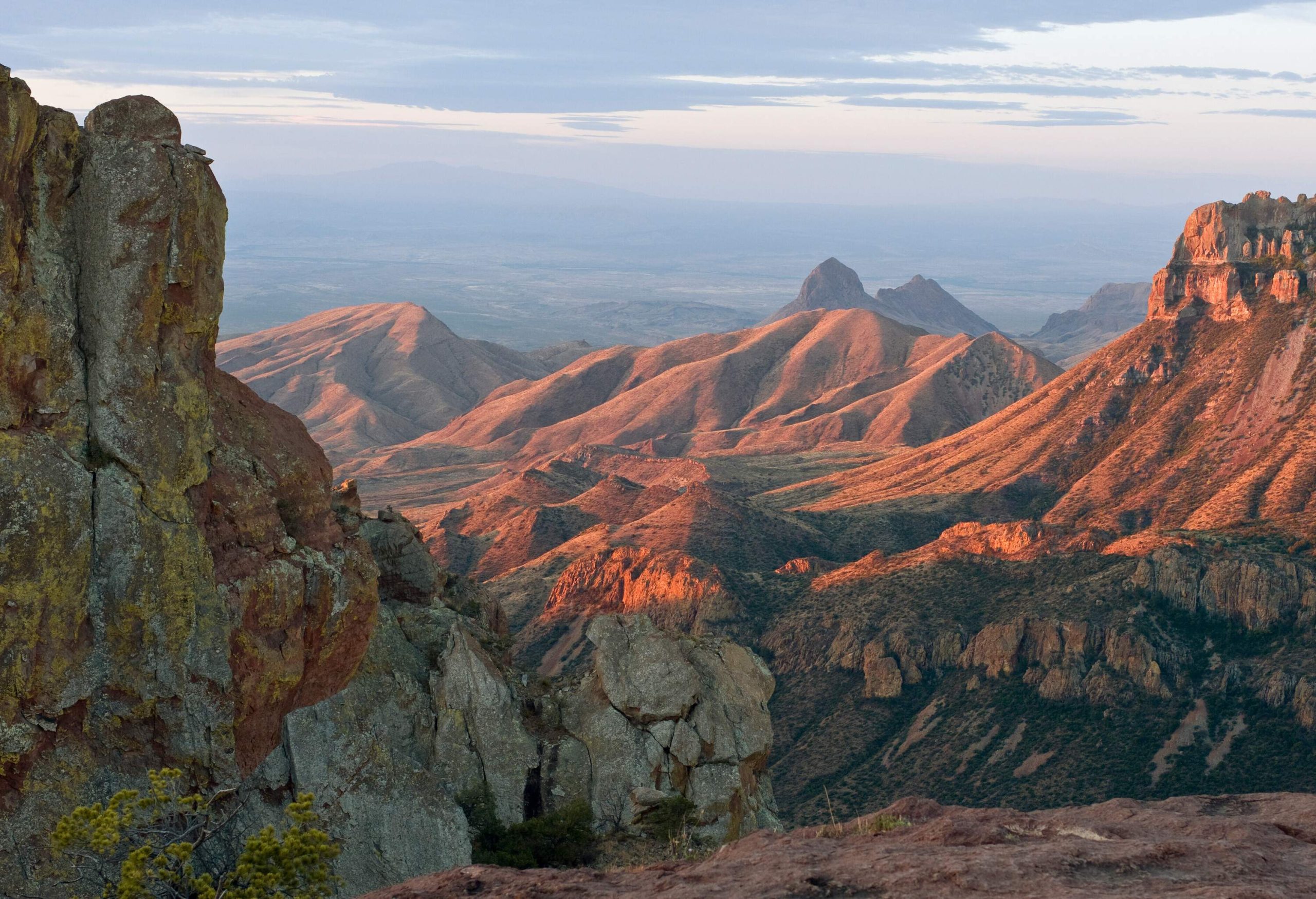 A mountainous terrain along steep canyons as seen from a mountain peak.