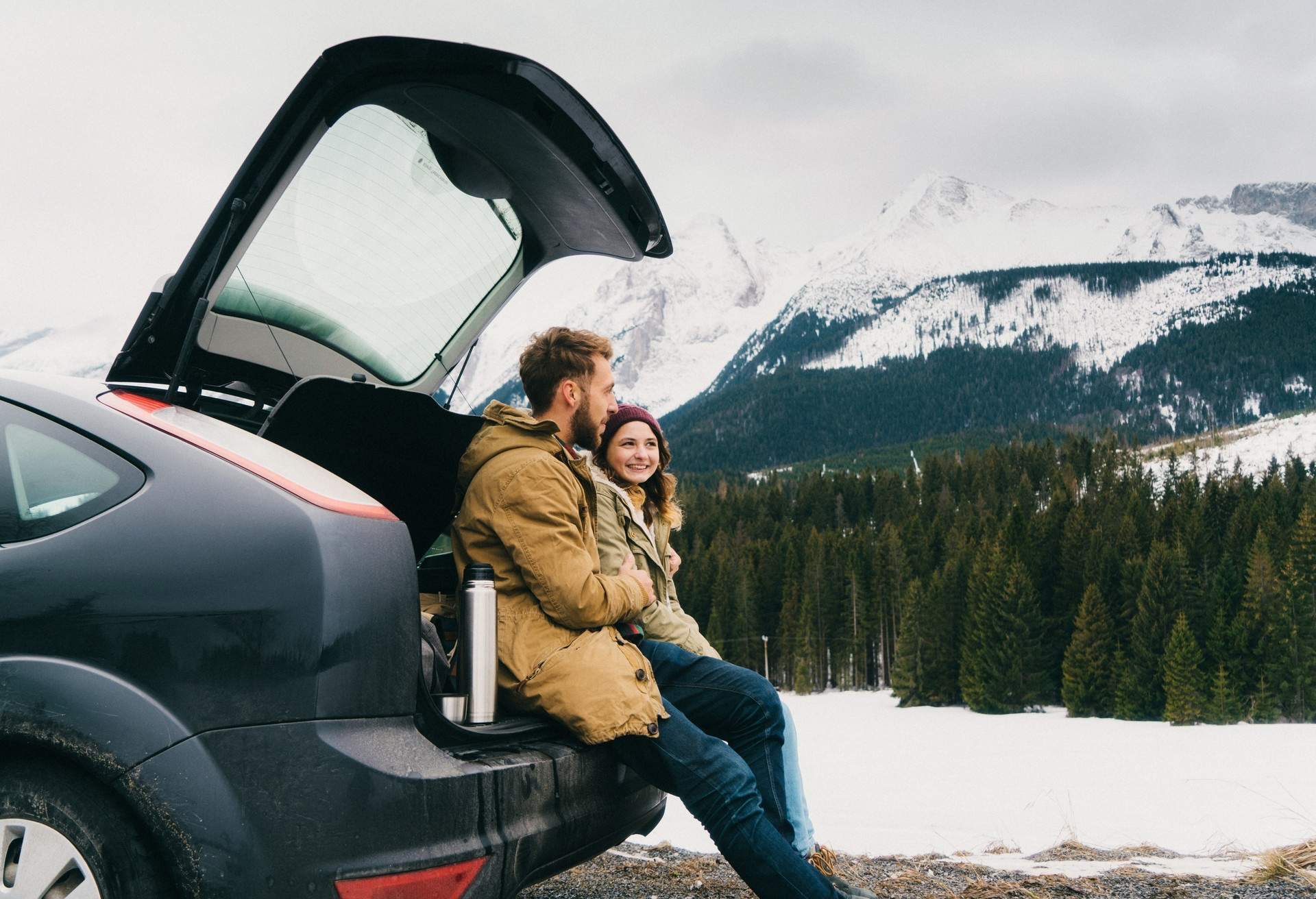 Young Caucasian couple resting near the car in mountains in winter DEST_POLAND_GettyImages-648954330