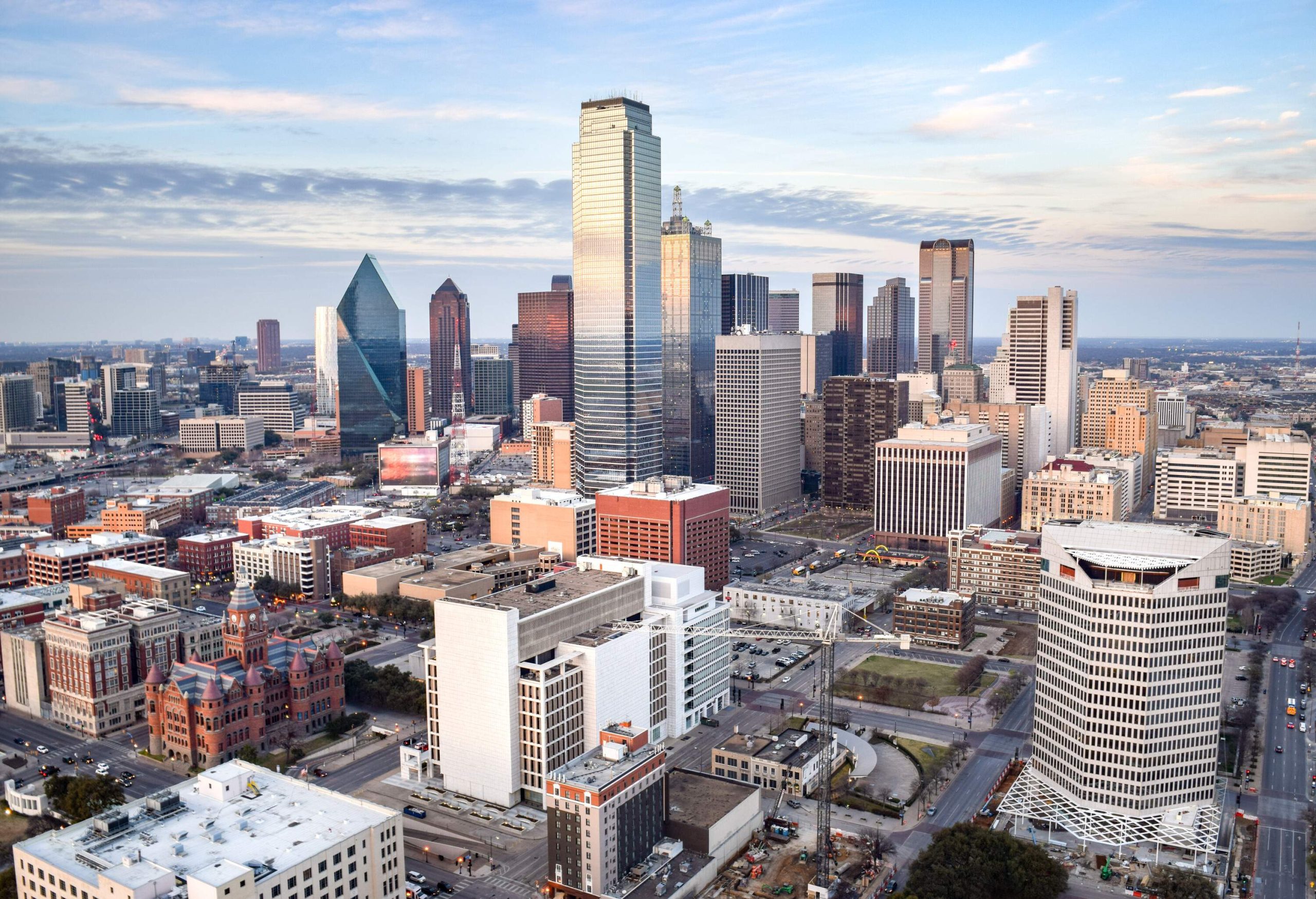 The skyline of a modern metropolis is characterized by classic buildings and towering skyscrapers set against a picturesque cloudy sky.