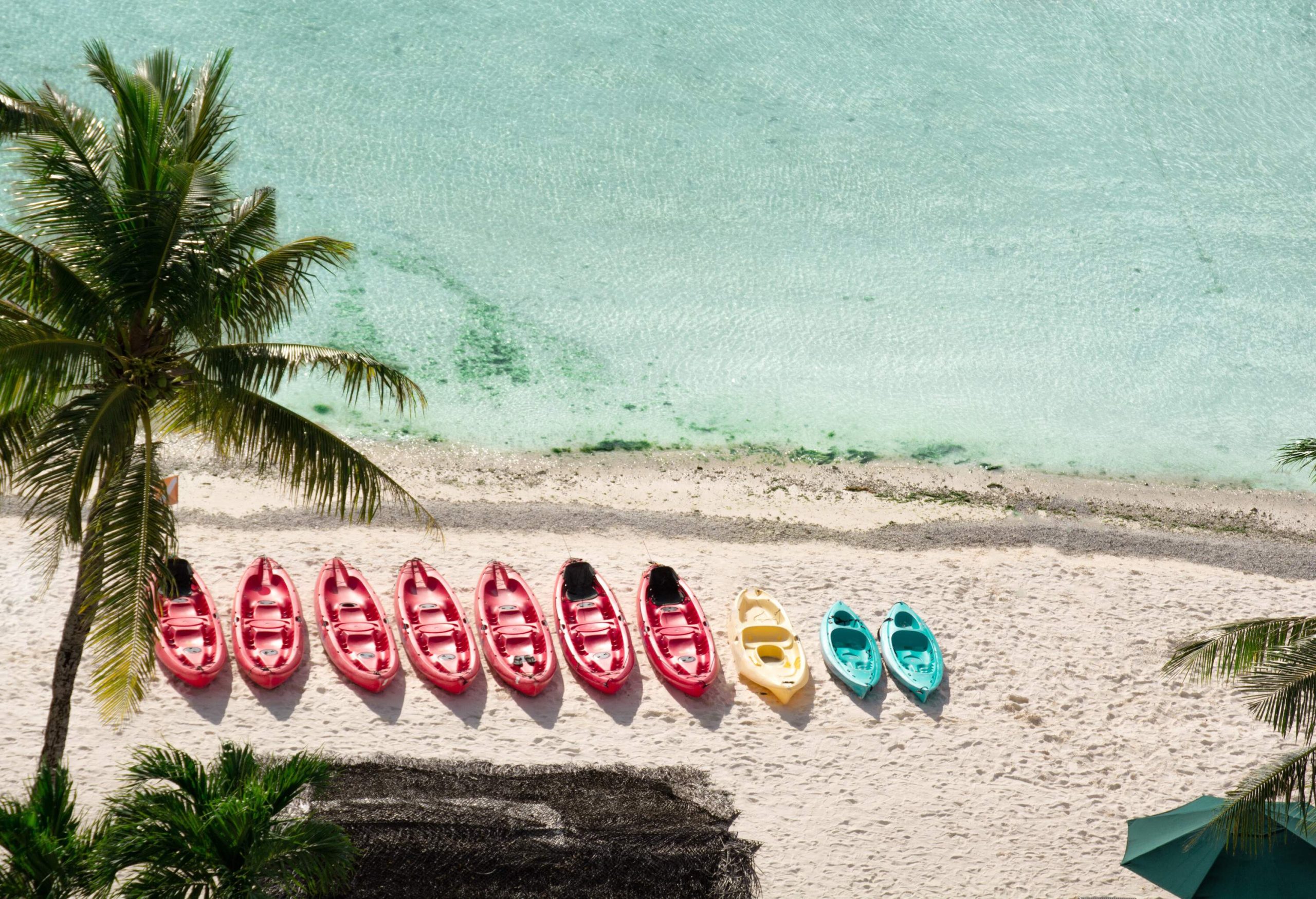 A row of colourful canoes is available for rental on the scenic, tranquil beach.