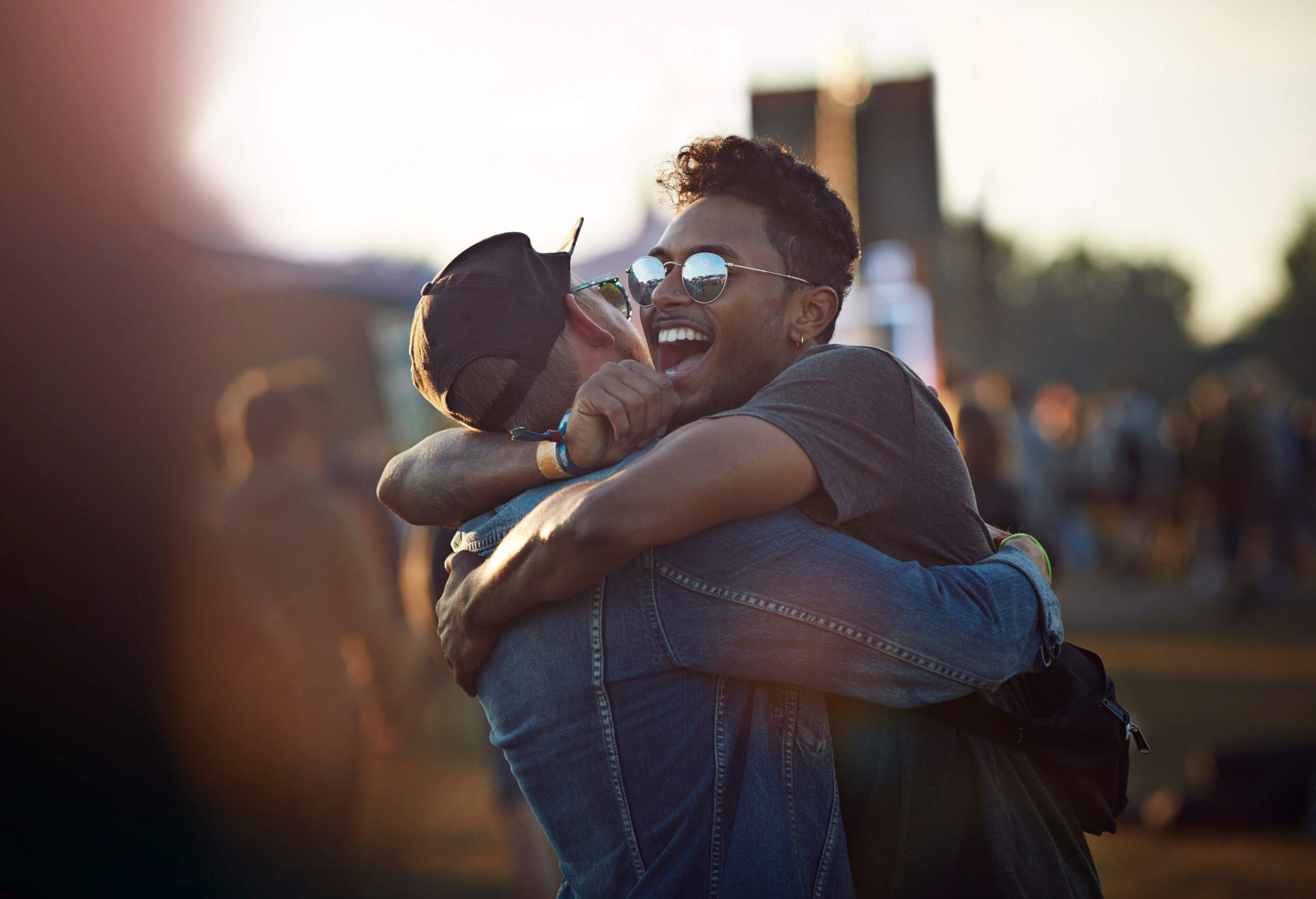 Two pals hugging each other in a crowded area.