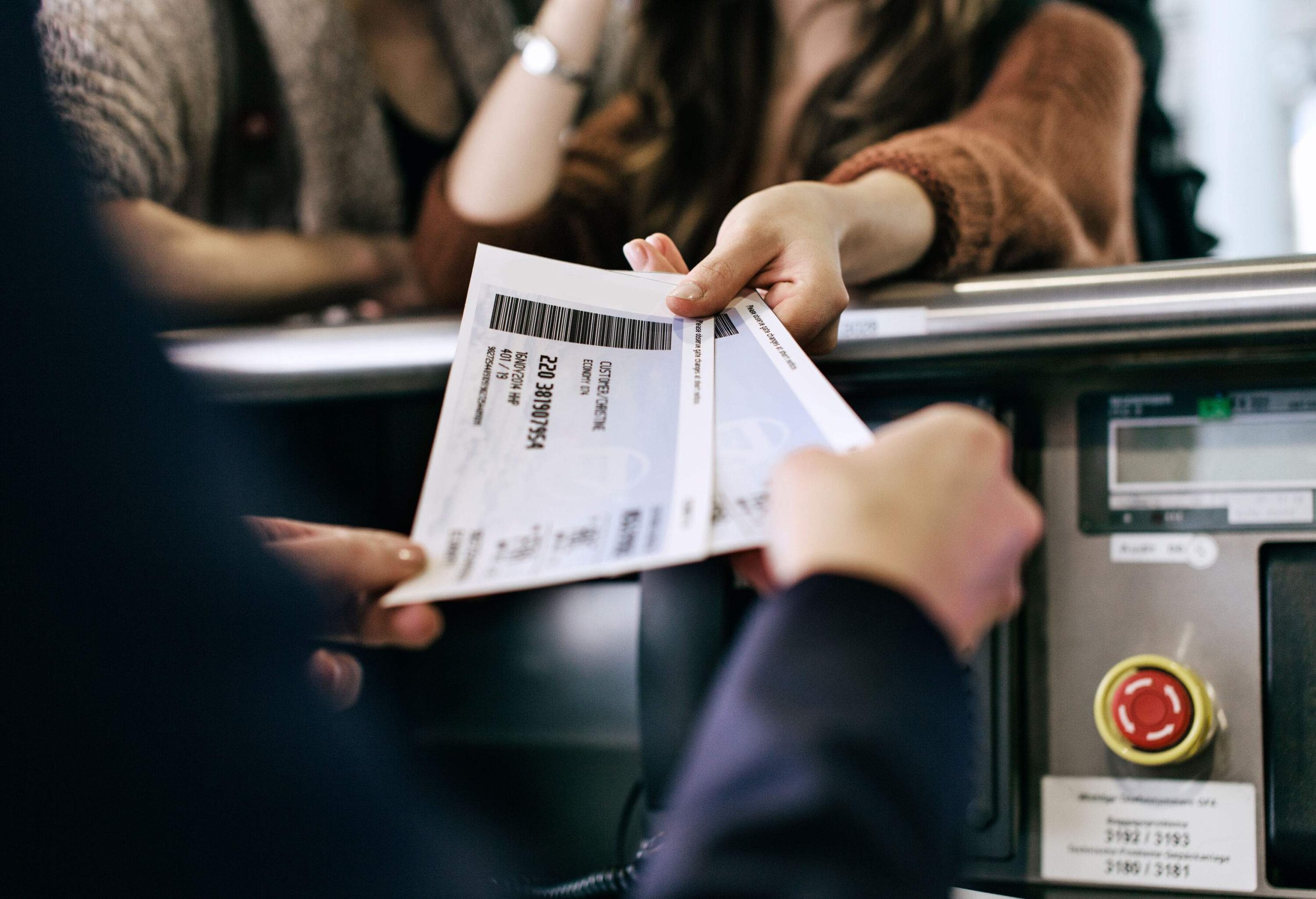 A woman presenting her boarding passes at the check-in counter.