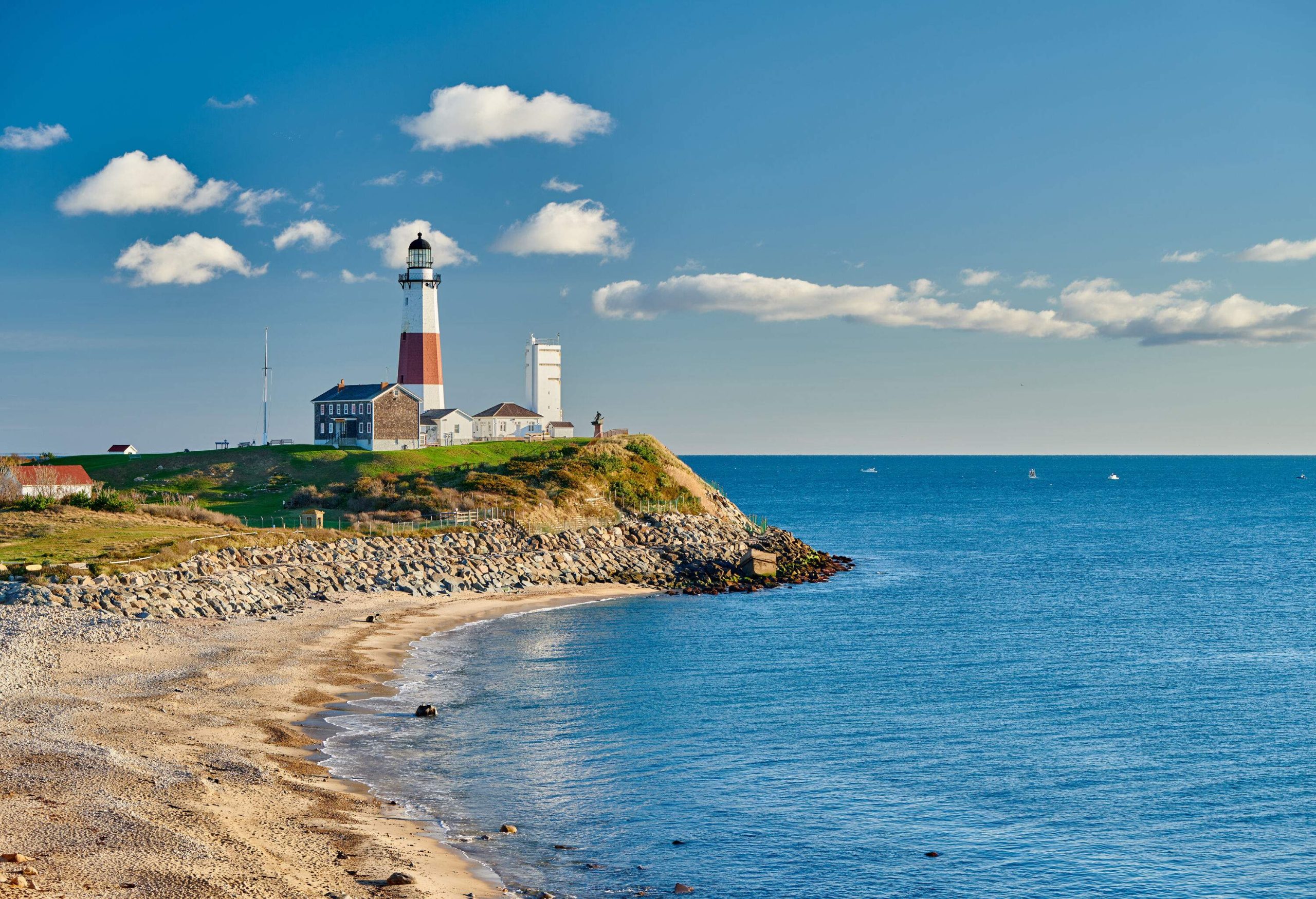 A red and white lighthouse on a coast's edge with vast ocean views.