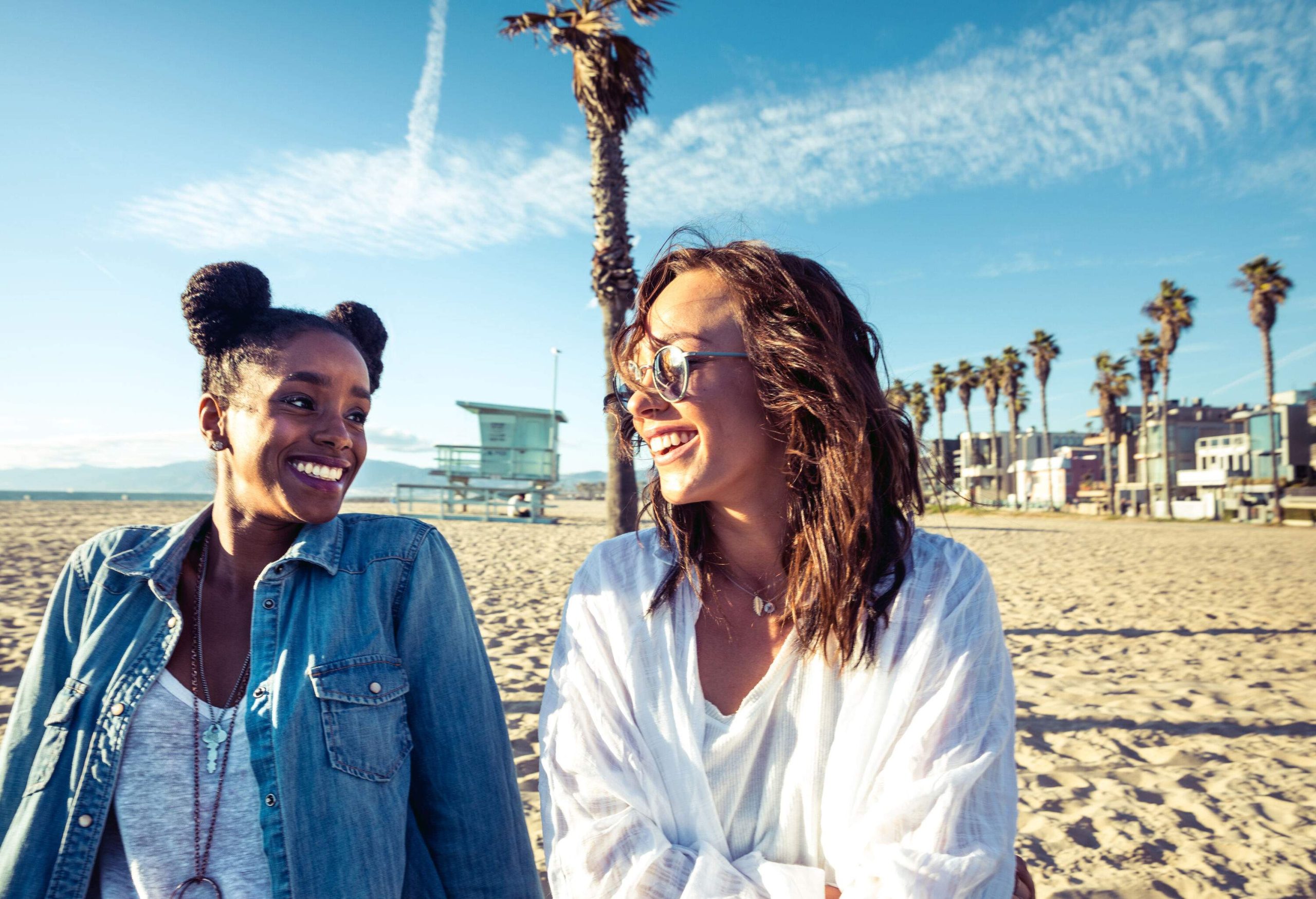 Two young ladies enjoying a day out on the beach beach on a beautiful sunny day.