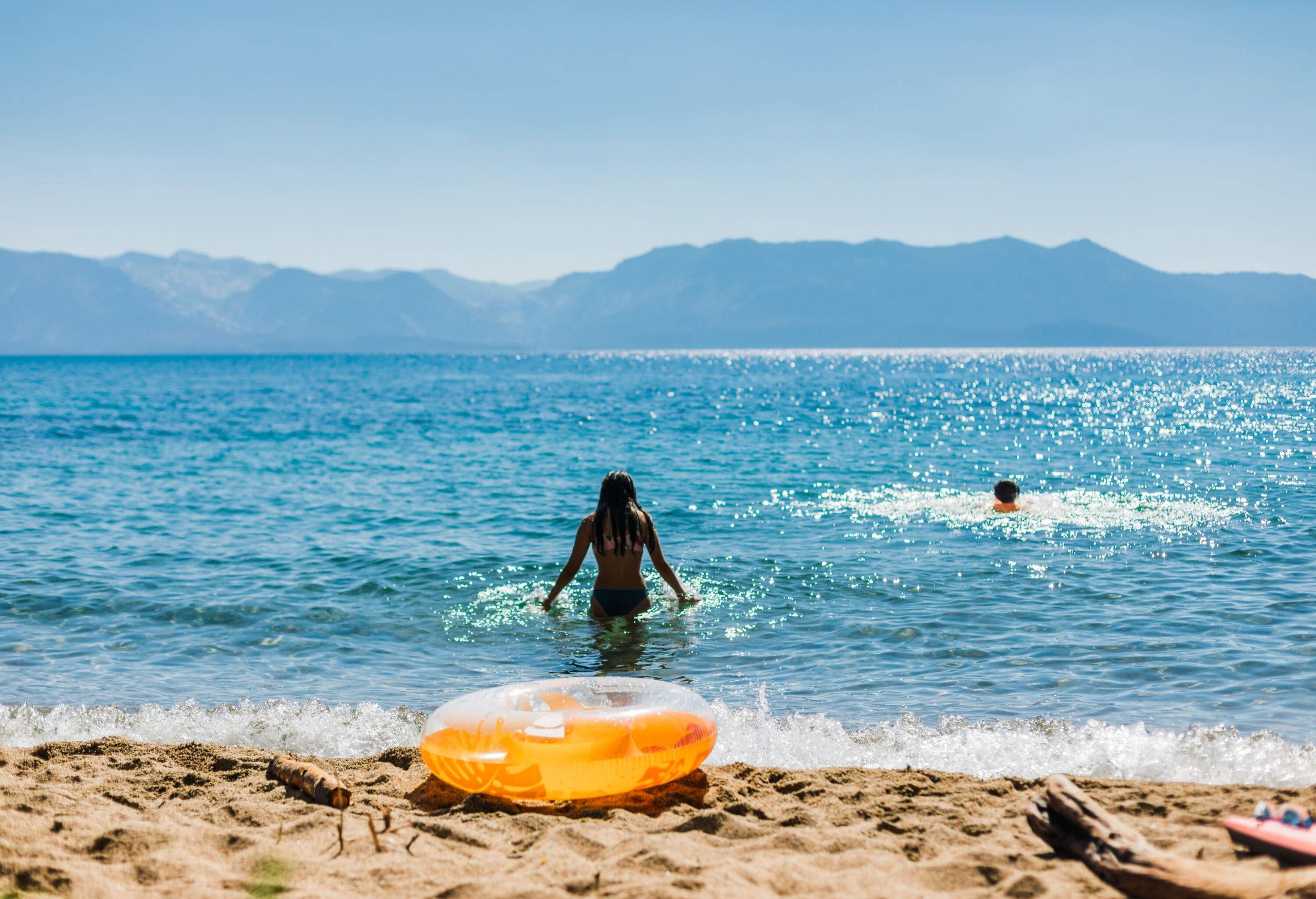 dest_usa_lake-tahoe_theme_woman_swimming_lake_mountain_inflatable_gettyimages-1277366585
