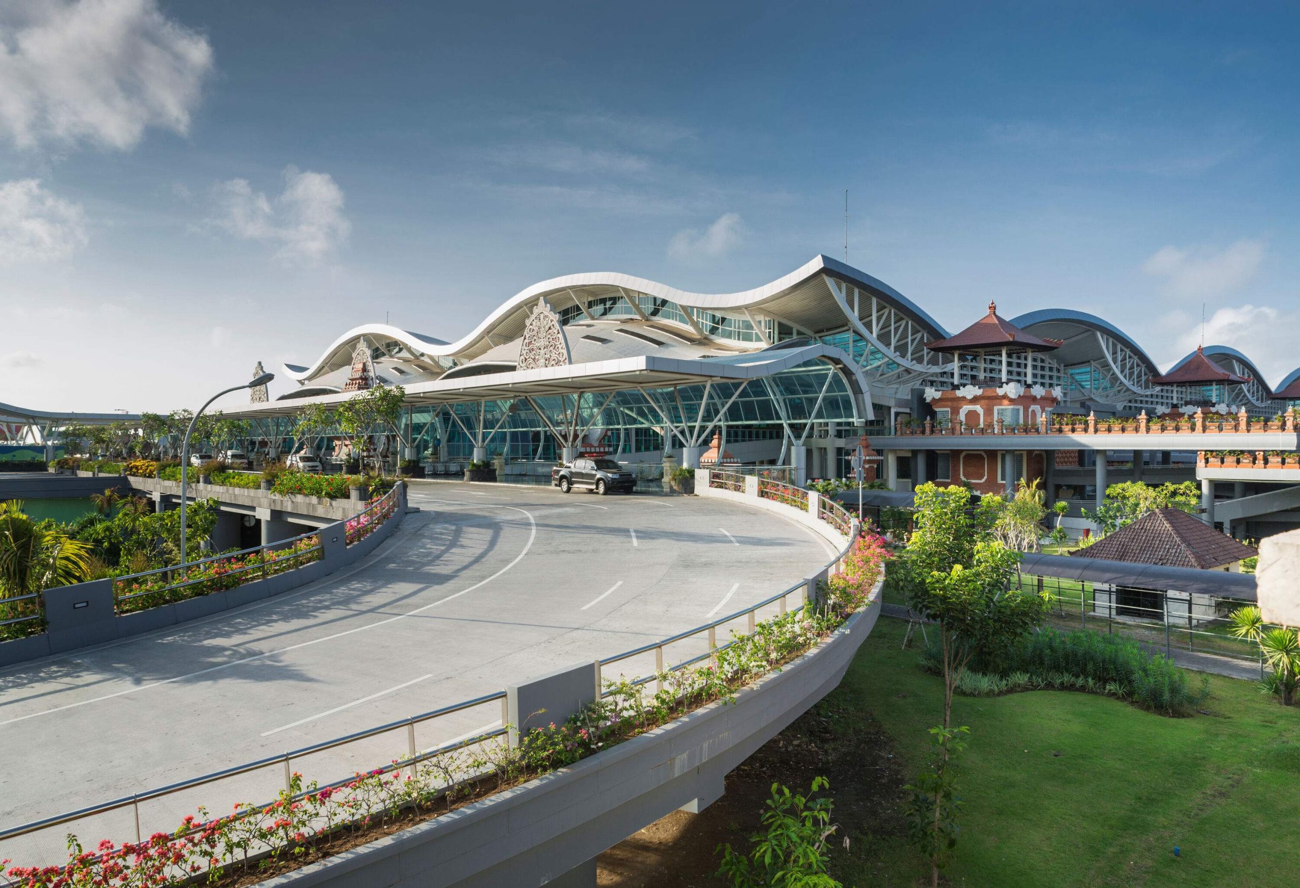 A modern airport façade with wide domes roof design and traditional pavilions along one side.