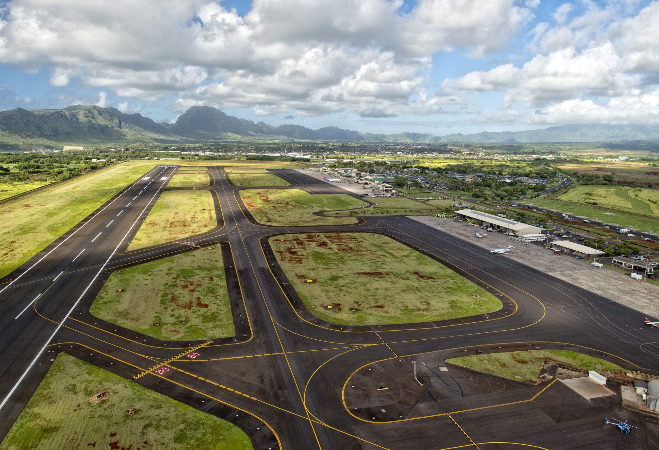 A tarmac dotted with green patches in between the runways and ramps.