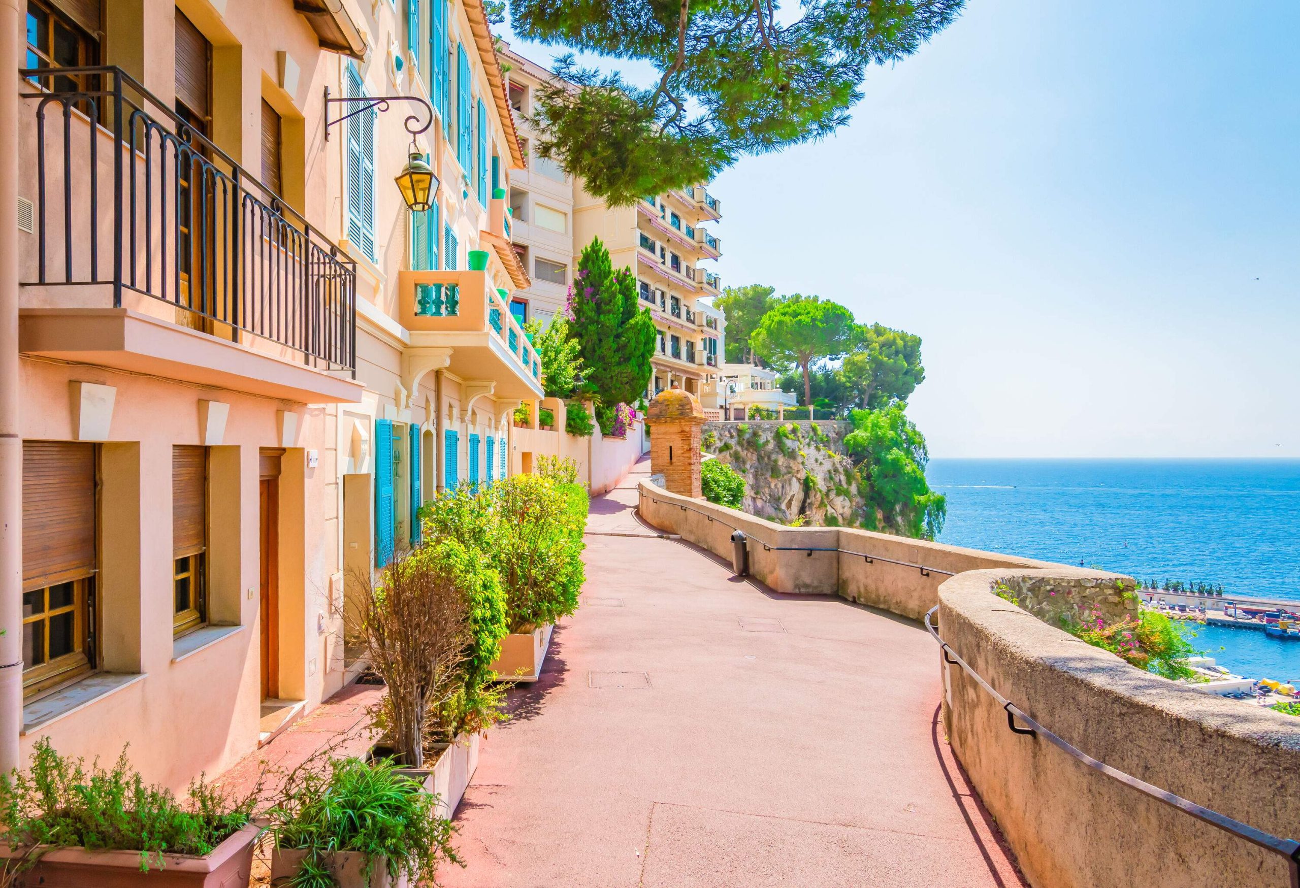 Attractive buildings along a narrow promenade overlooking the sea.