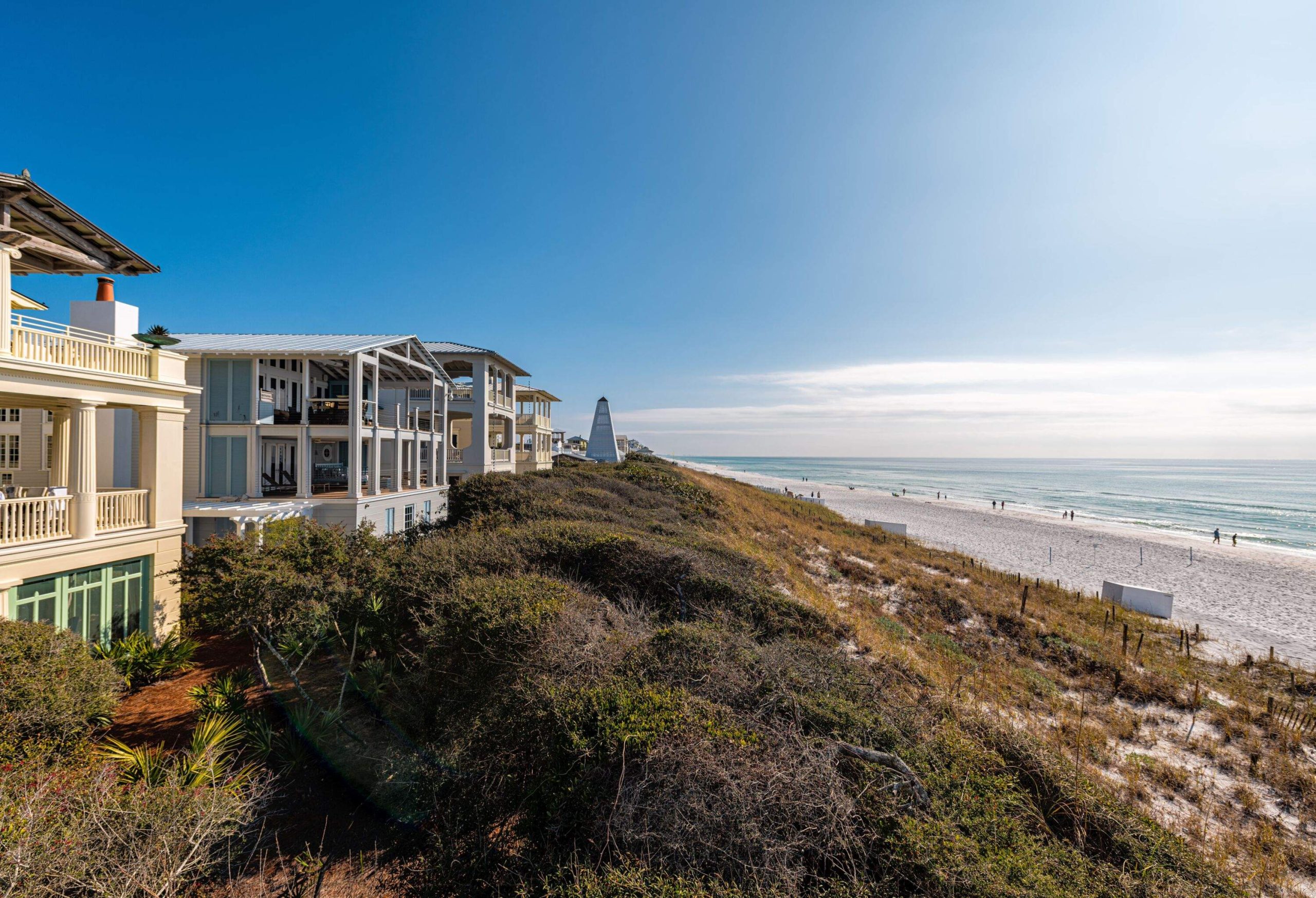 High angle view from wooden pavilion gazebo by beach at Gulf of Mexico at Seaside, Florida by new urbanism rental house home architecture with people walking on ocean sea coast