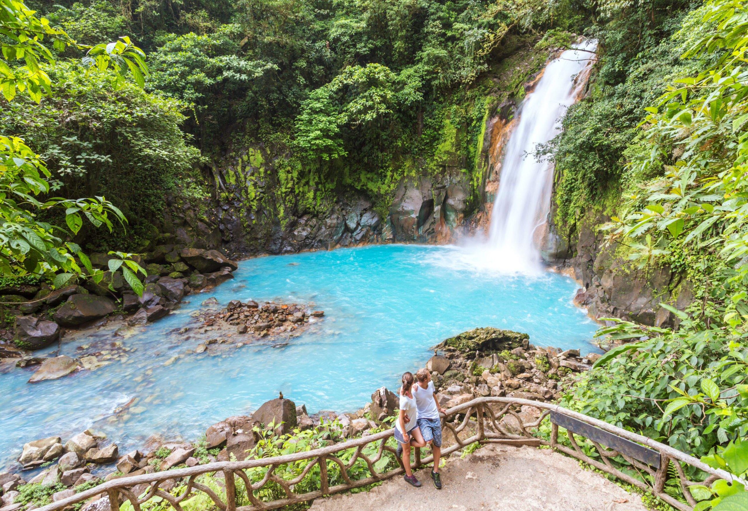 Tourist couple looking at Rio Celeste waterfall, Tenorio Volcano National Park, Guanacaste, Costa Rica