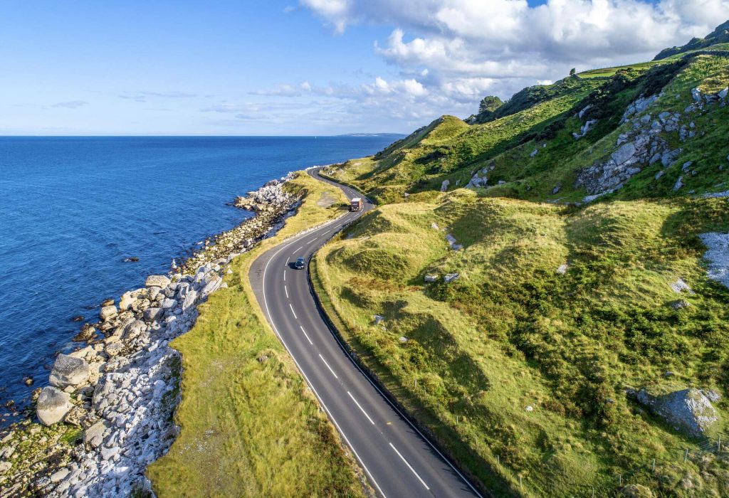 Irish coast road with 2 cars driving