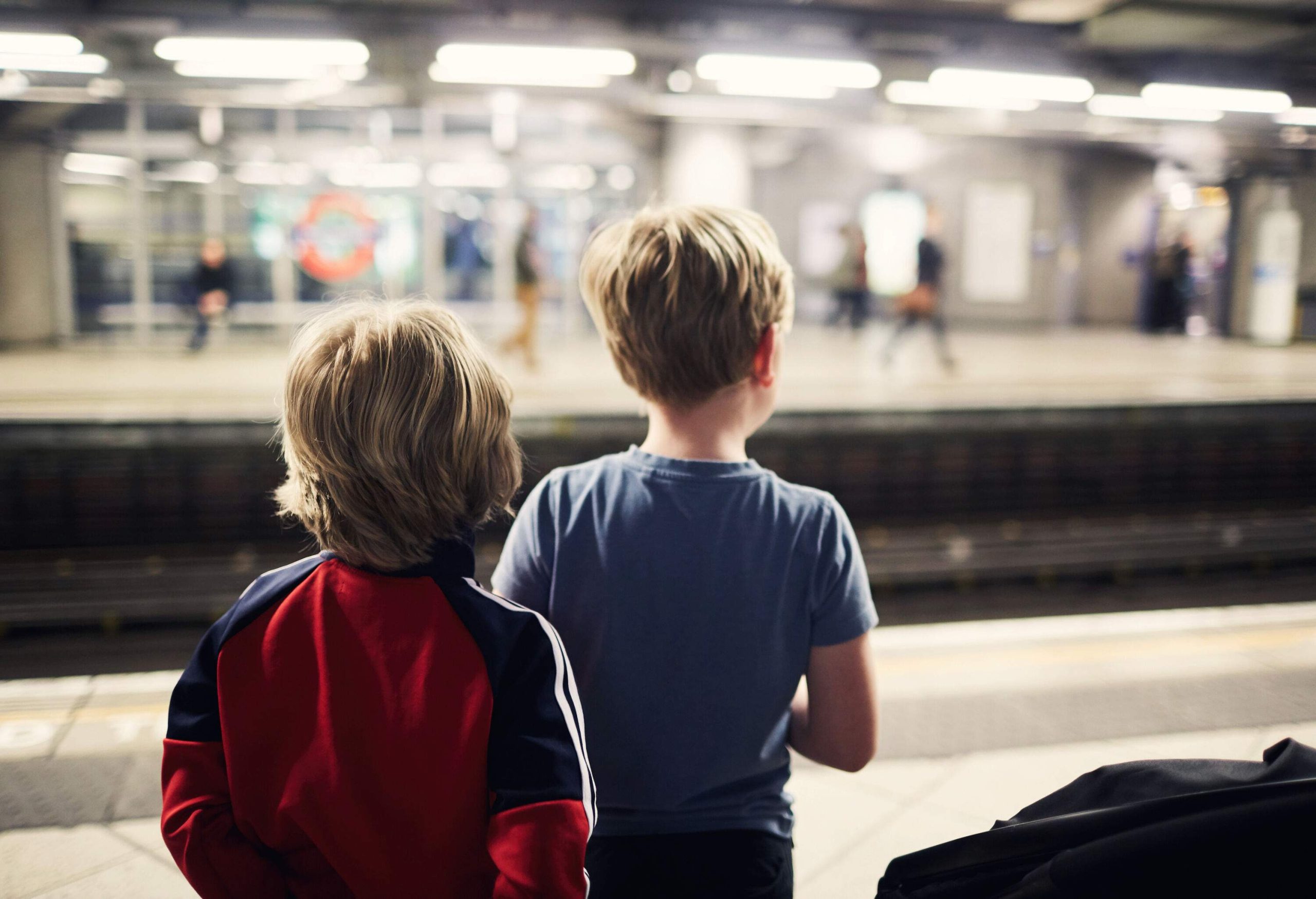 Two little boys waiting for a train at a metro station.