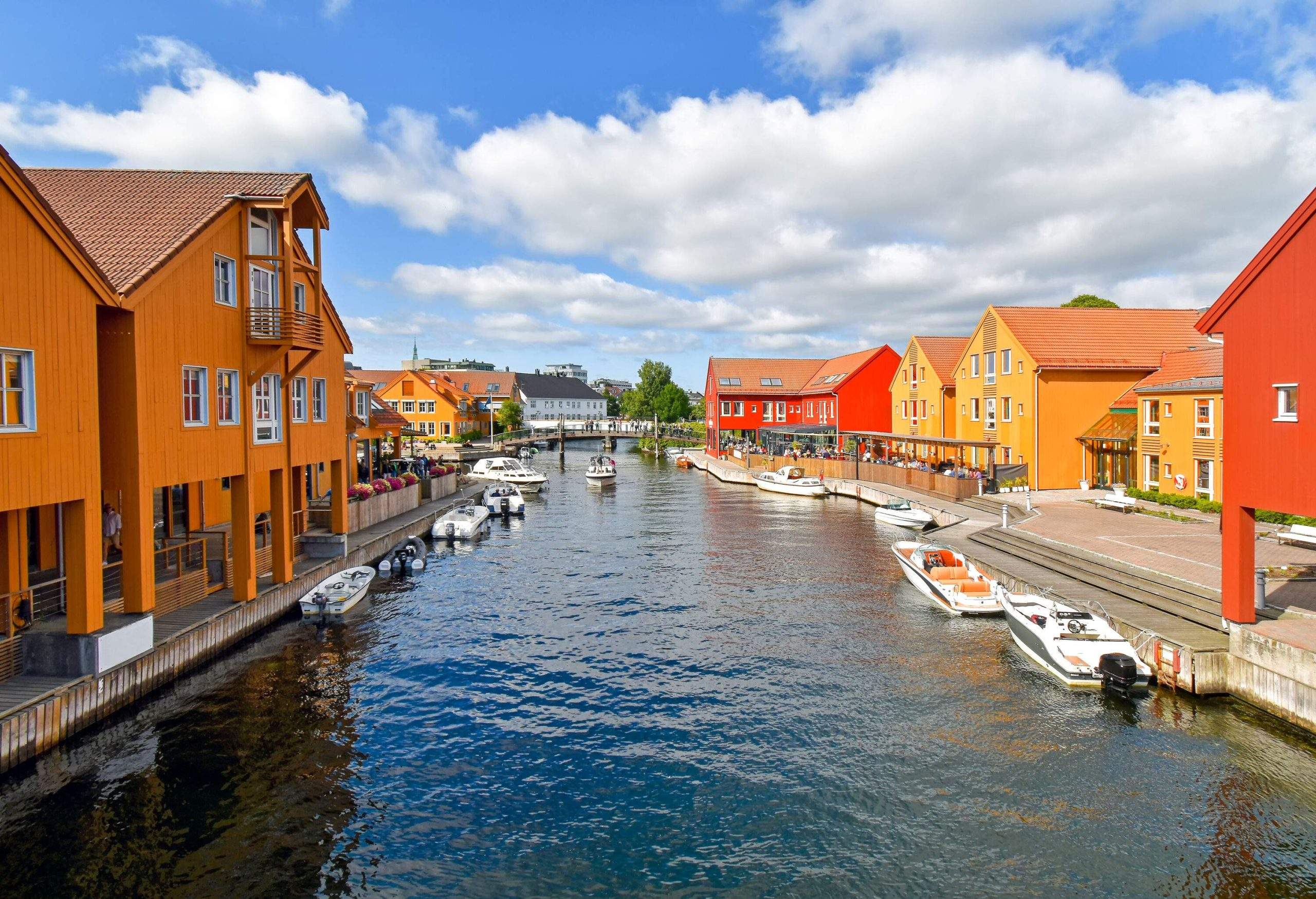 A waterfront scene featuring moored boats alongside buildings adorned in shades of orange.