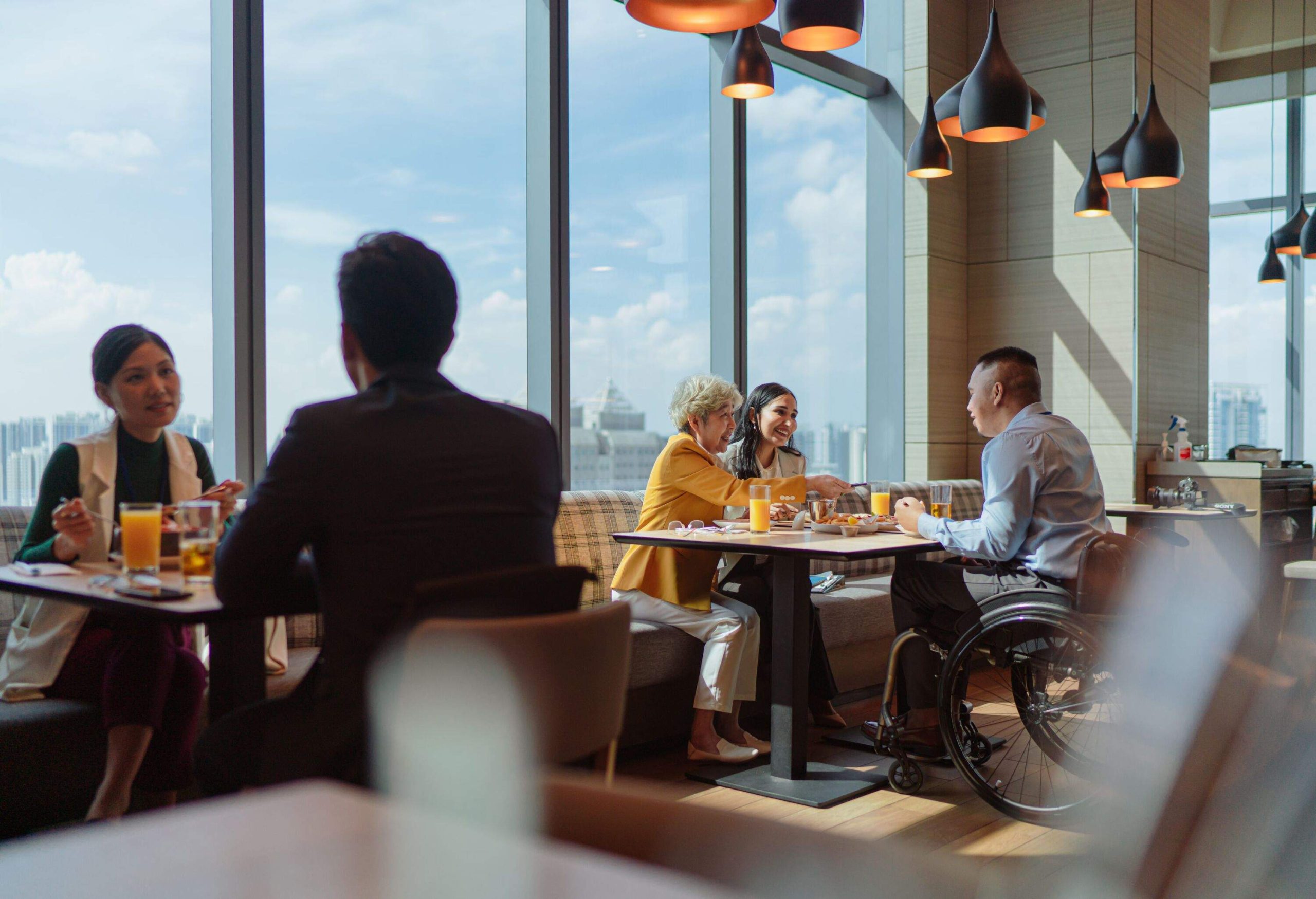 Business meet - Senior Asian businesswoman and her diverse team of coworkers bonding over a meal