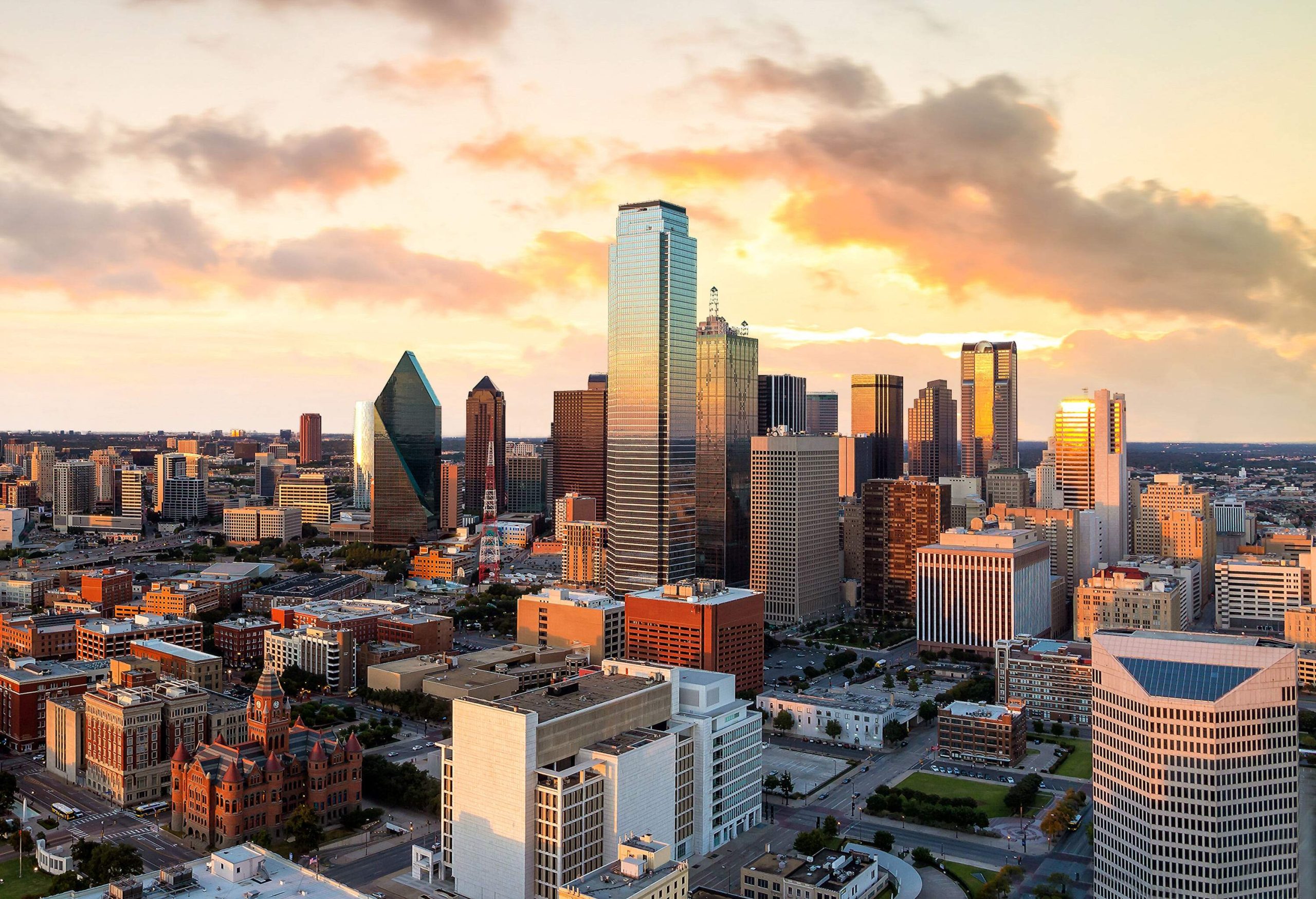 The cityscape dominated by a cluster of skyscrapers protruding into the scenic sky.