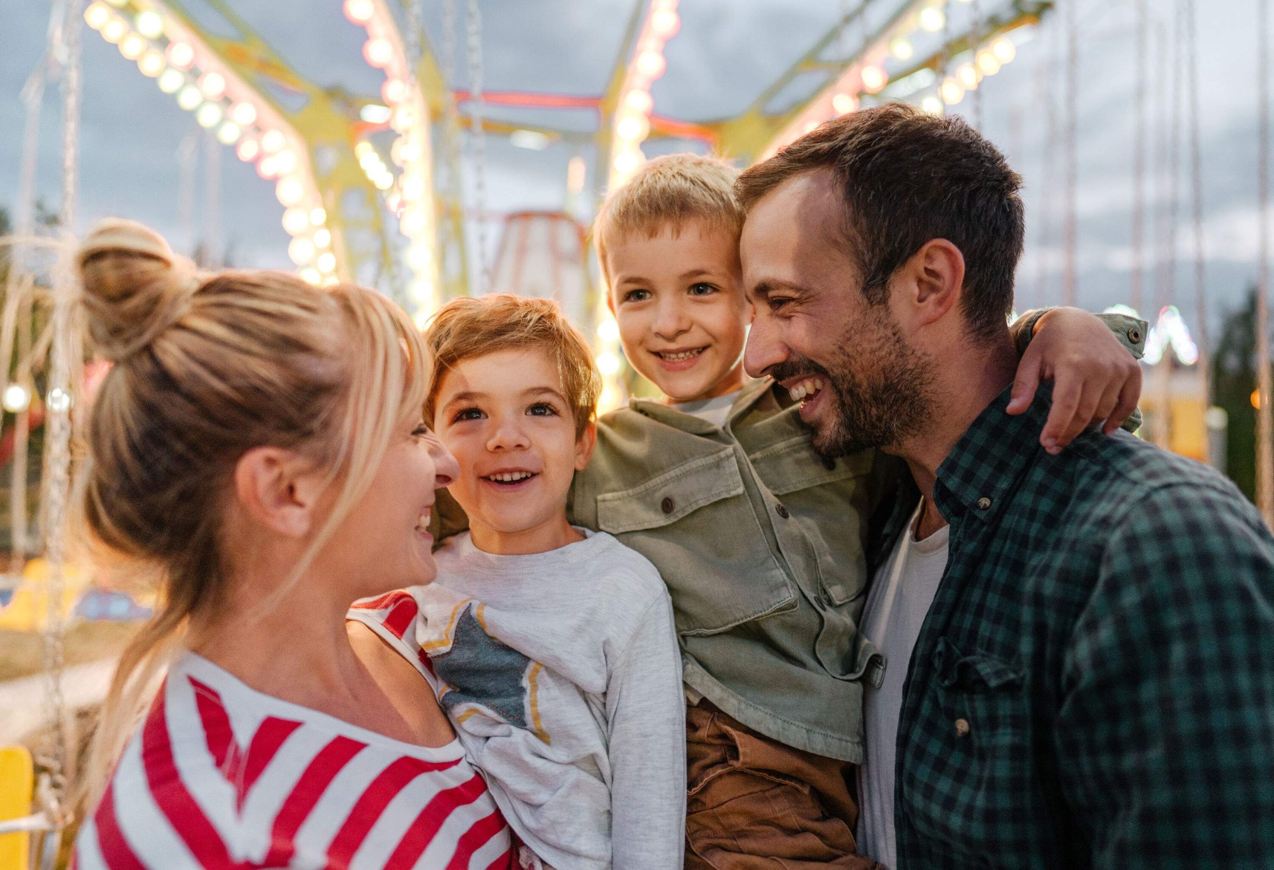 Portrait of a happy family of four with bright bokeh background.