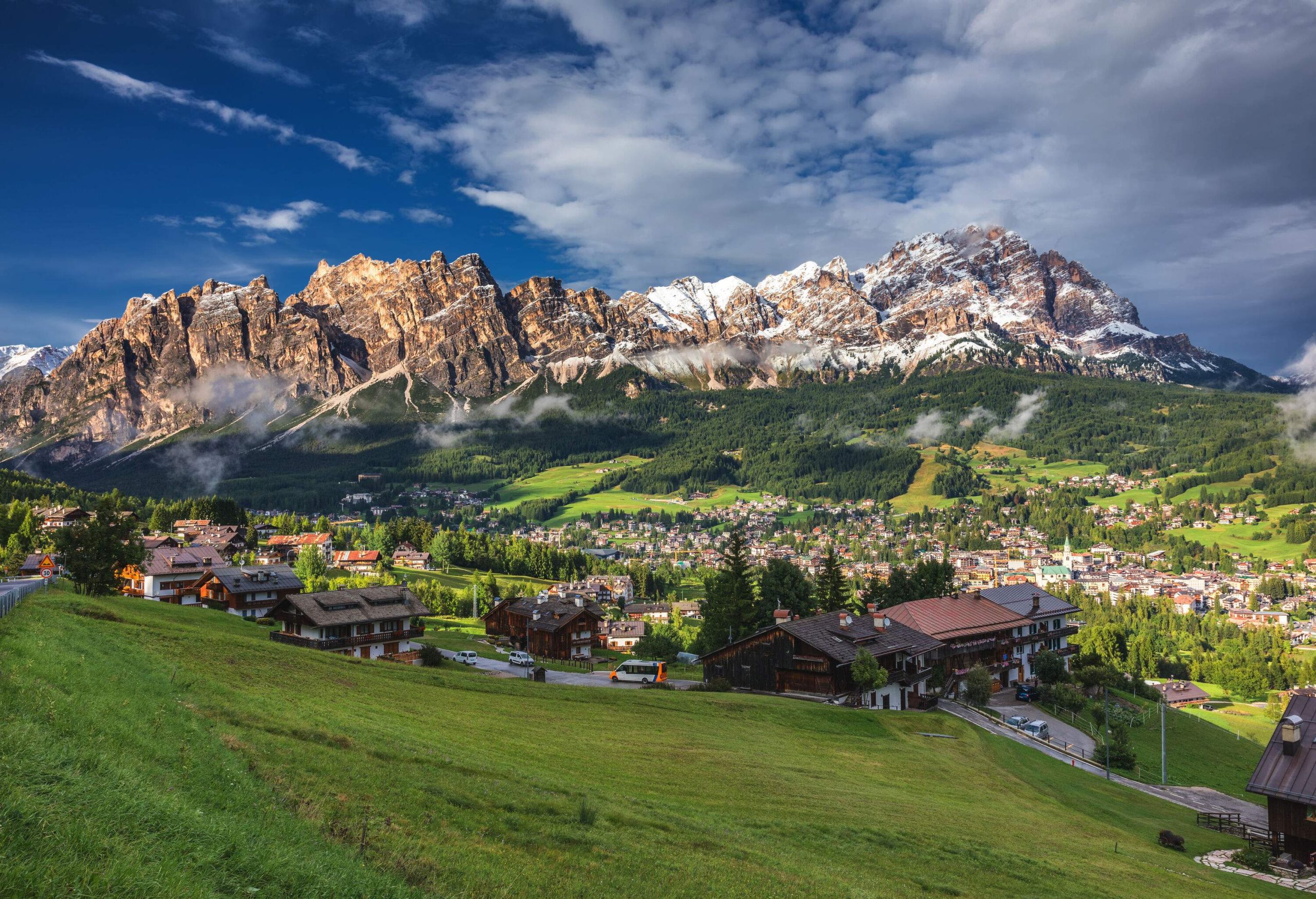 A beautiful resort town with chalet-style houses and villages across the valley in the foothills of the Alps.