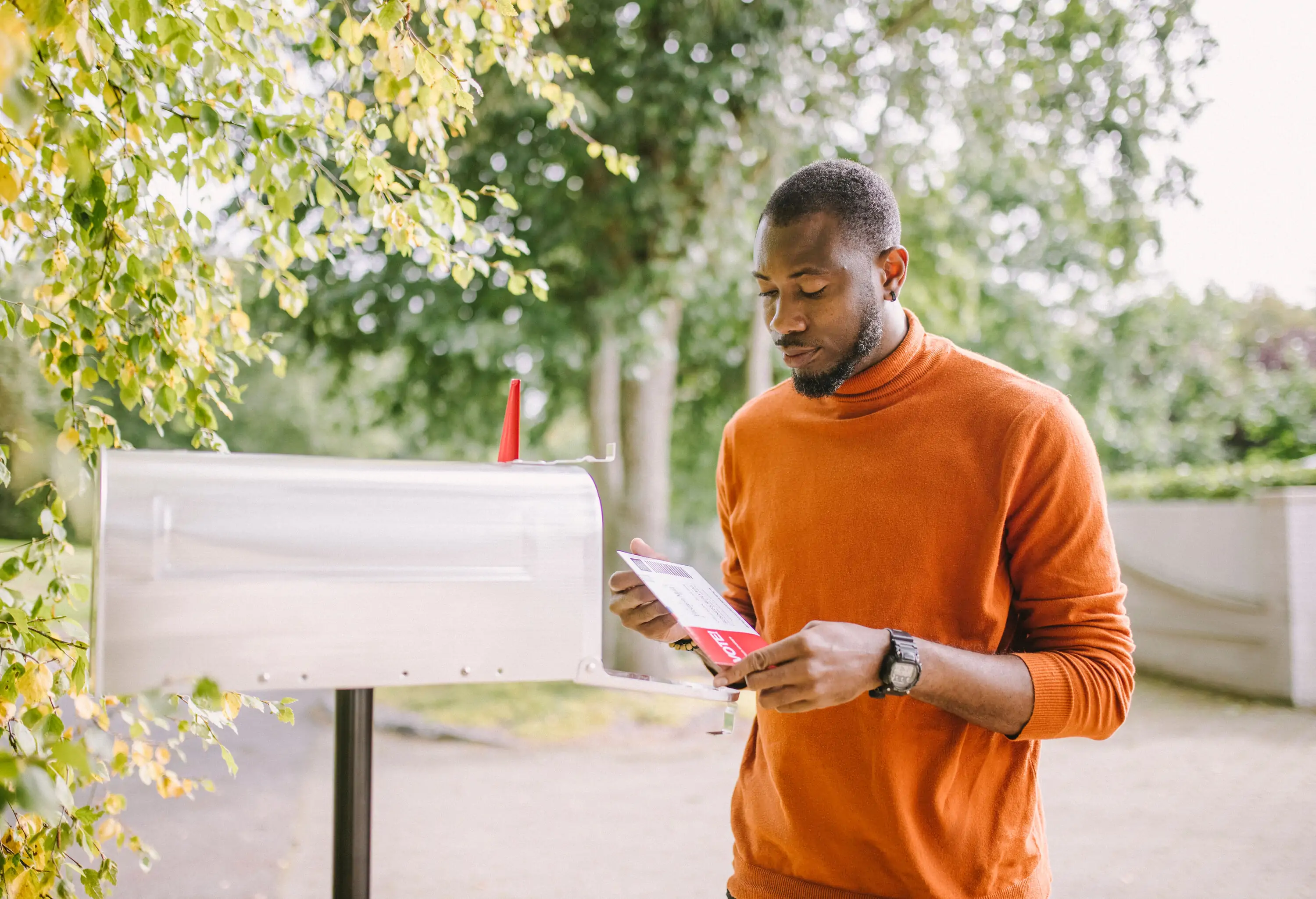 Portrait of African-American man receiving mail-in voting ballot.