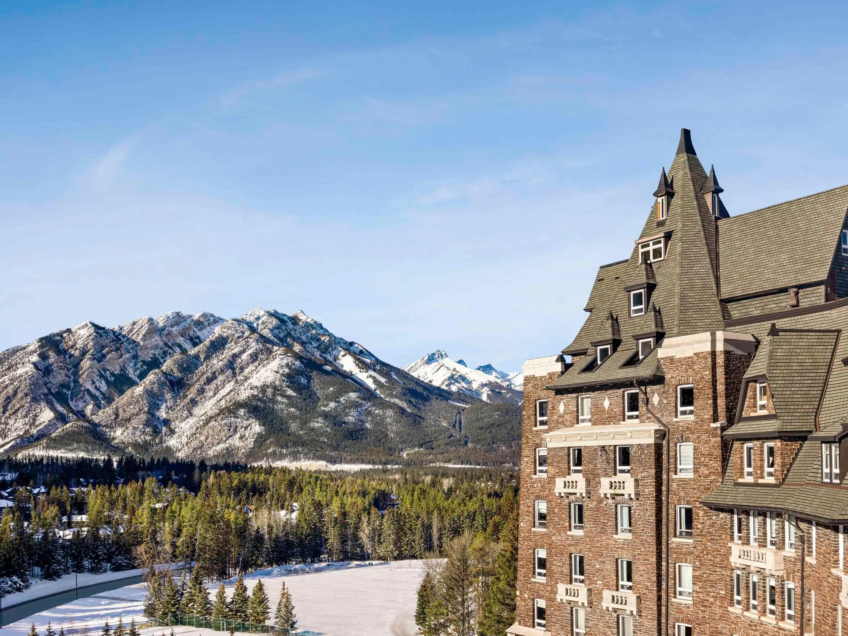 Large building overlooking snowy mountain landscape