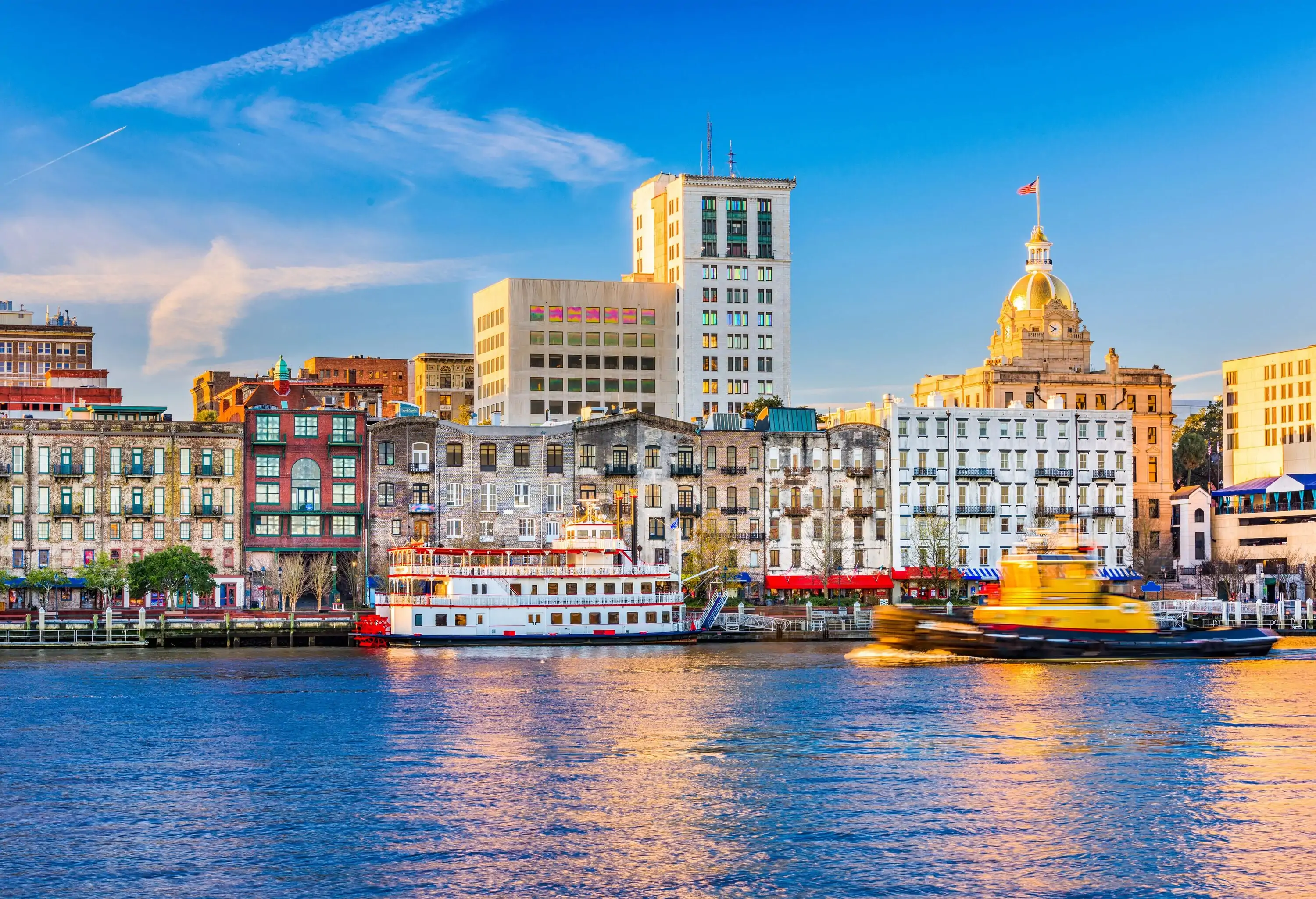 A river harbour with anchored ferries along the waterfront buildings.