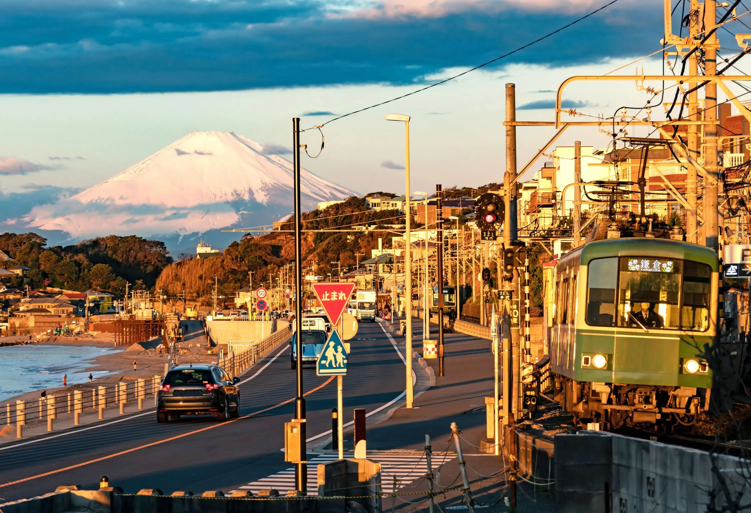 The sea is Sagami Bay, Pacific Ocean and the local train is Enoden, Enoshima Electric Railway running between Kamakurakokomae and Shichirigahama station, Kamakura city, at golden hour