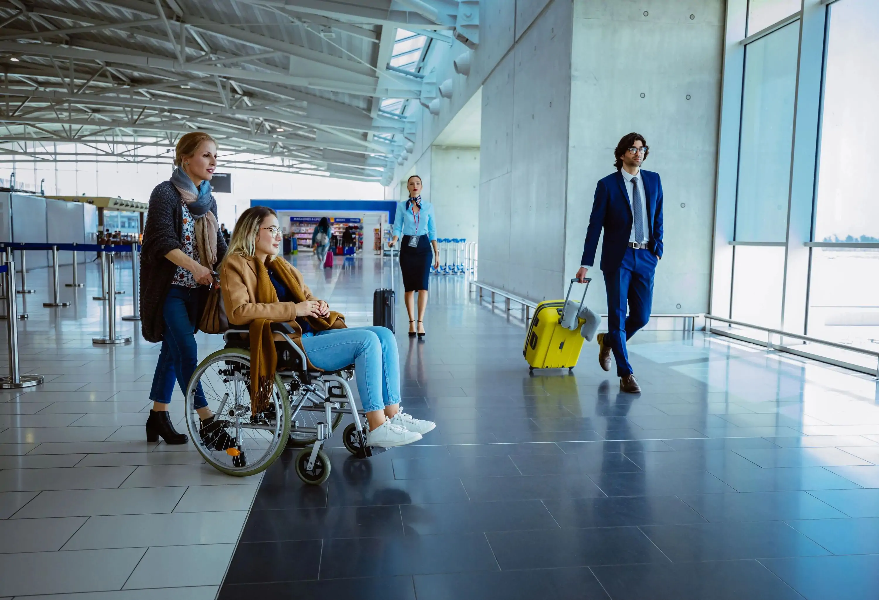 Diverse group of passengers walking and standing on international airport corridor with window