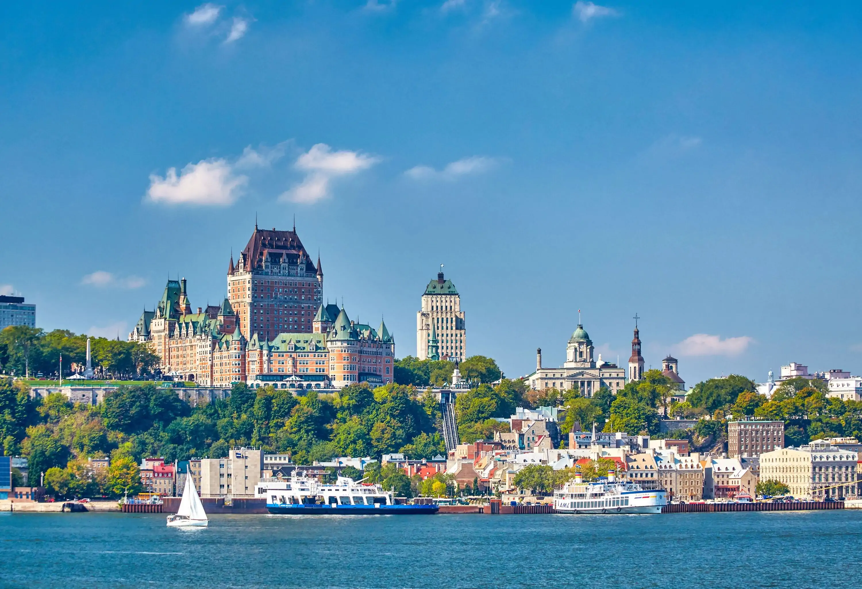 View of a city with old castle by a body of water on a clear summer day