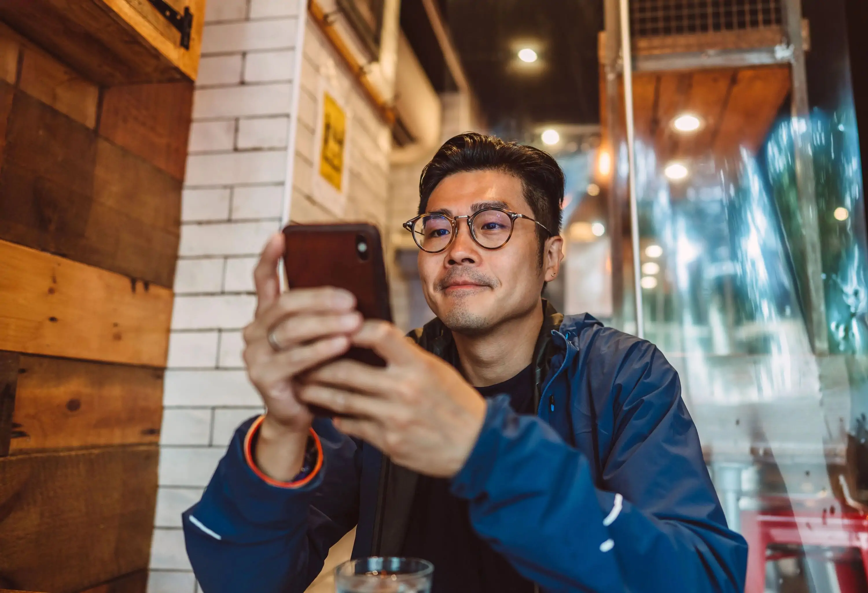 Asian man on his smartphone in restaurant.