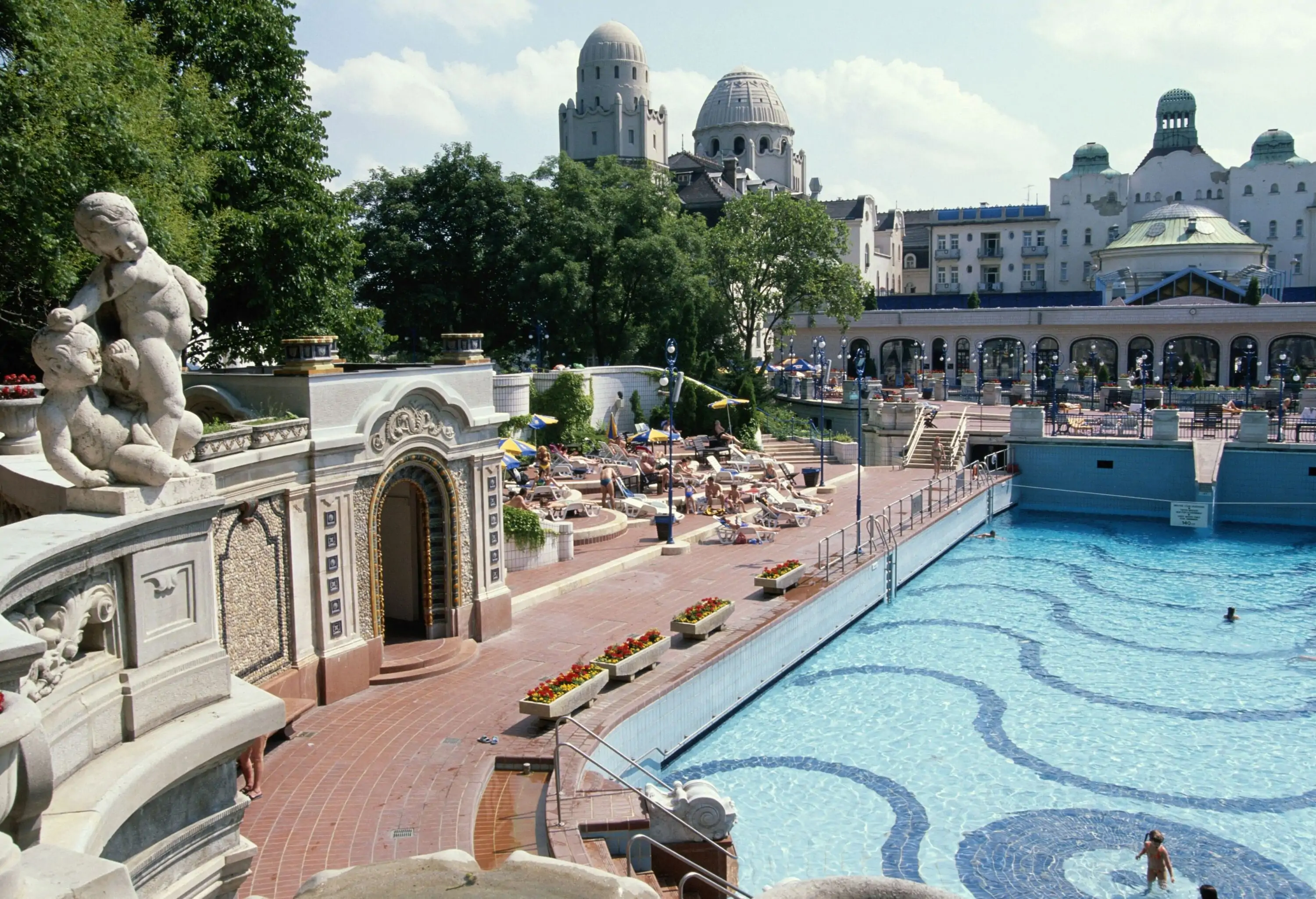 A thermal bath swimming pool in front of a classic domed white building.