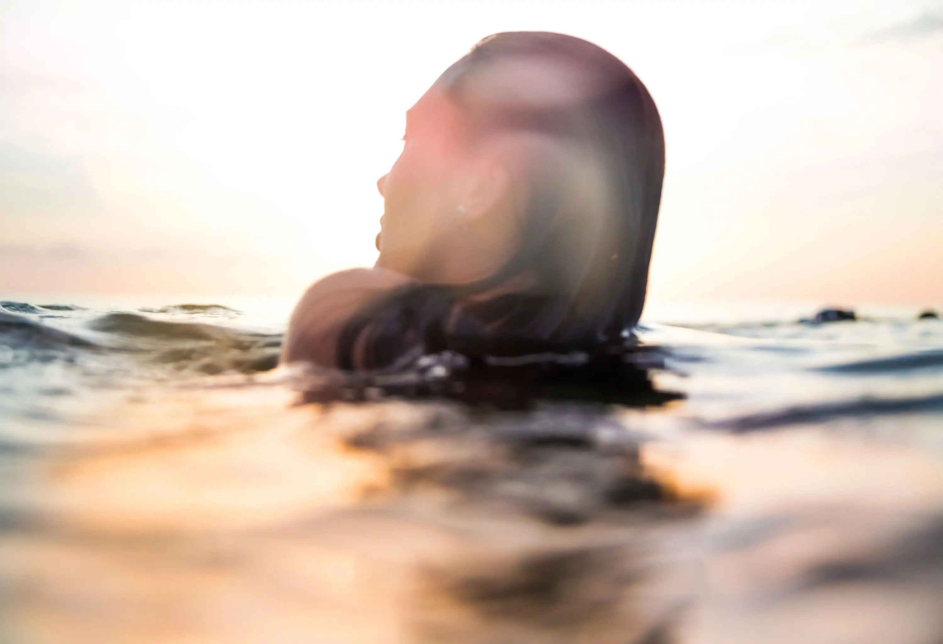 A woman's head above the surface of the water.
