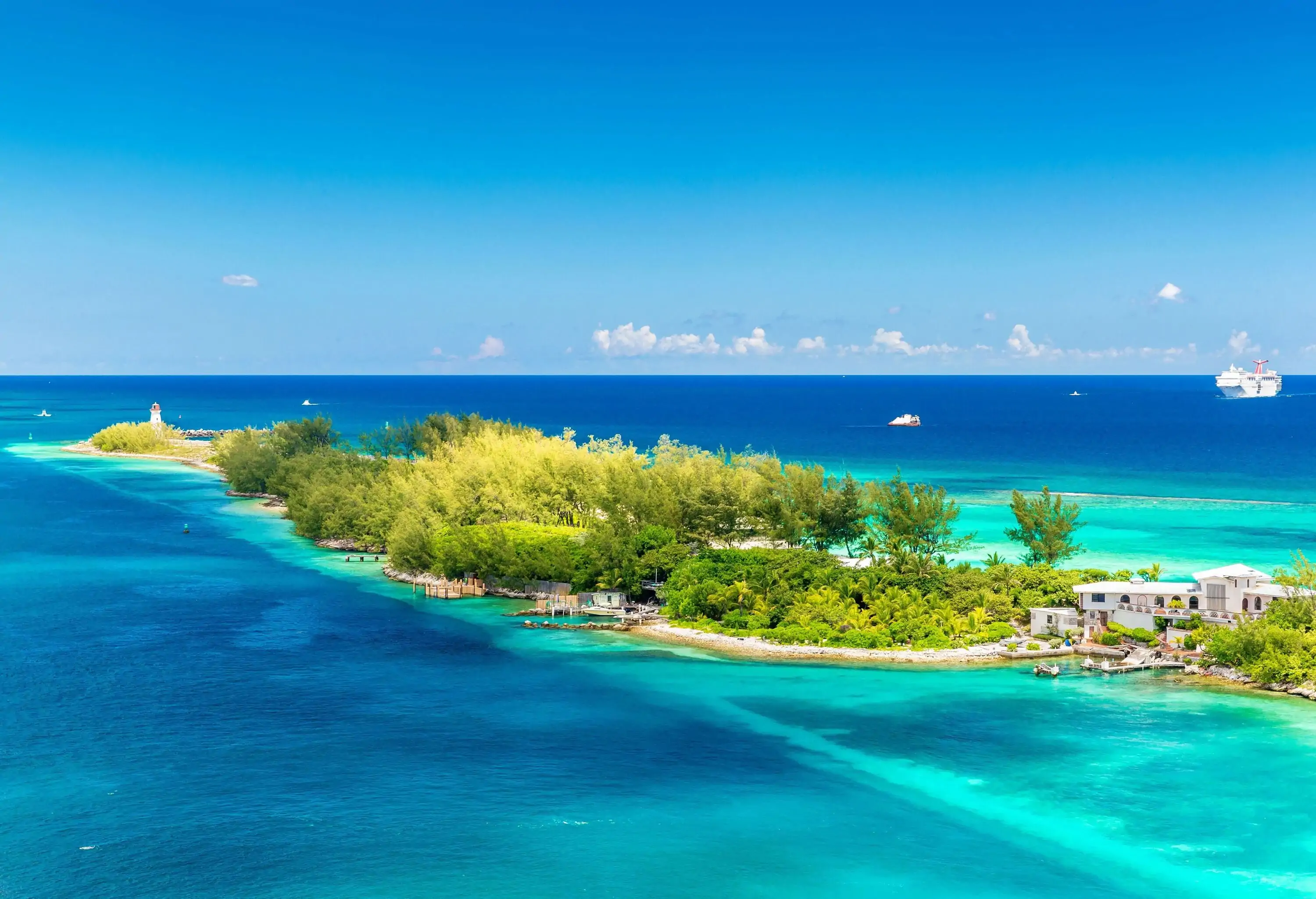 An island abundant with lush foliage, where a solitary building is perched, creating a harmonious blend of nature and human habitation in a serene and picturesque setting.