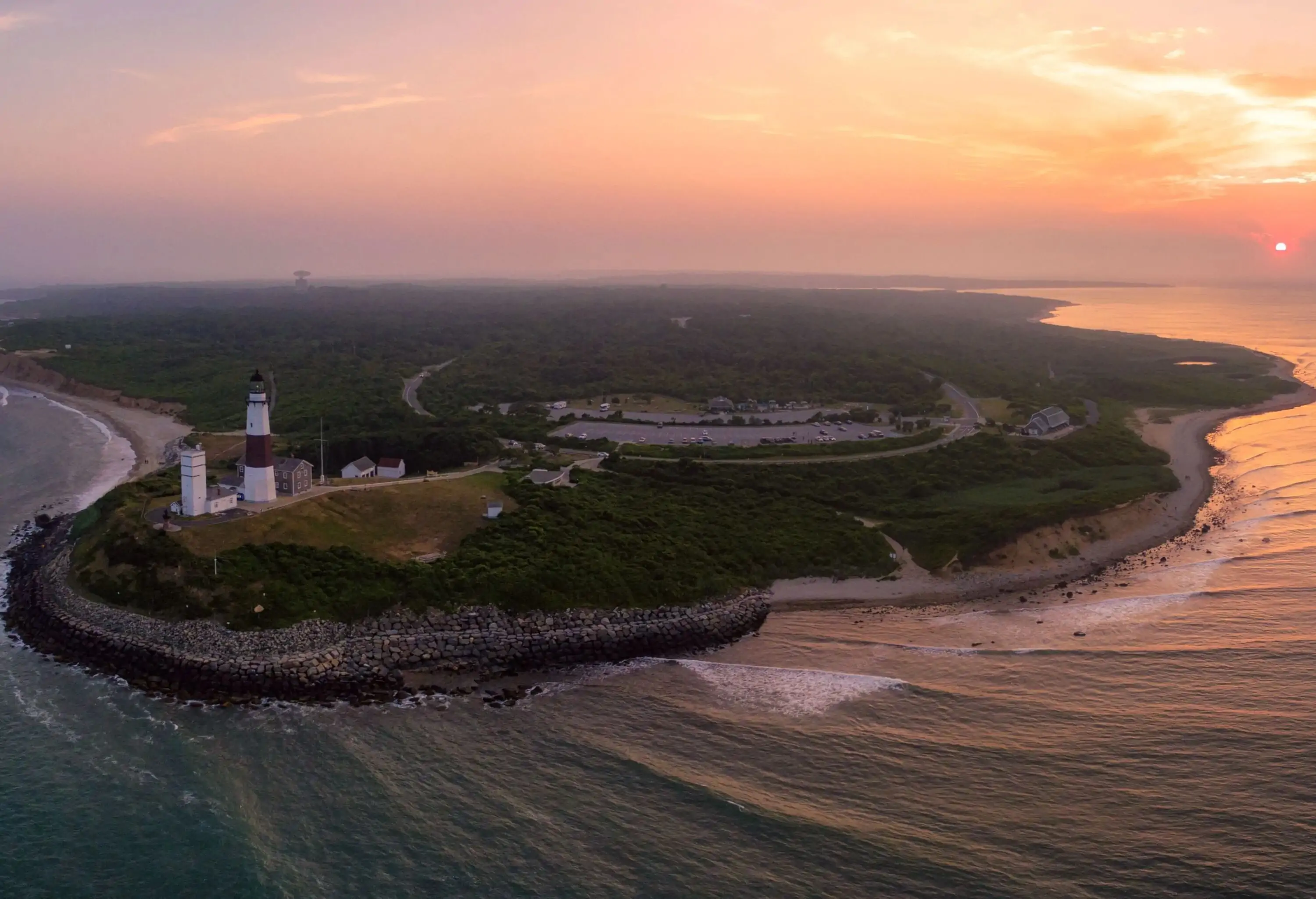 A white lighthouse in an island village under the beautiful sunset skies.