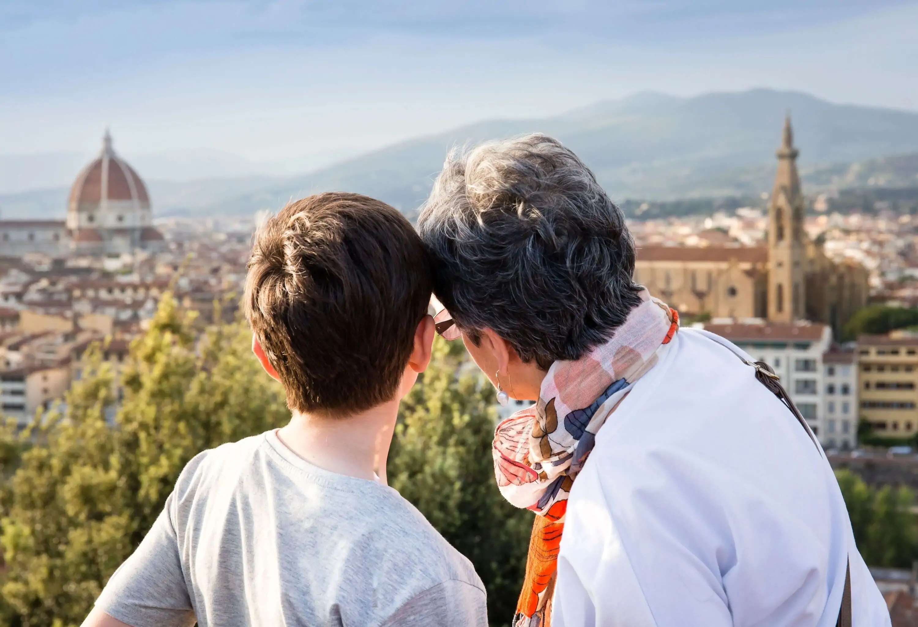 A kid and an older person gaze into the urban setting of the metropolis.