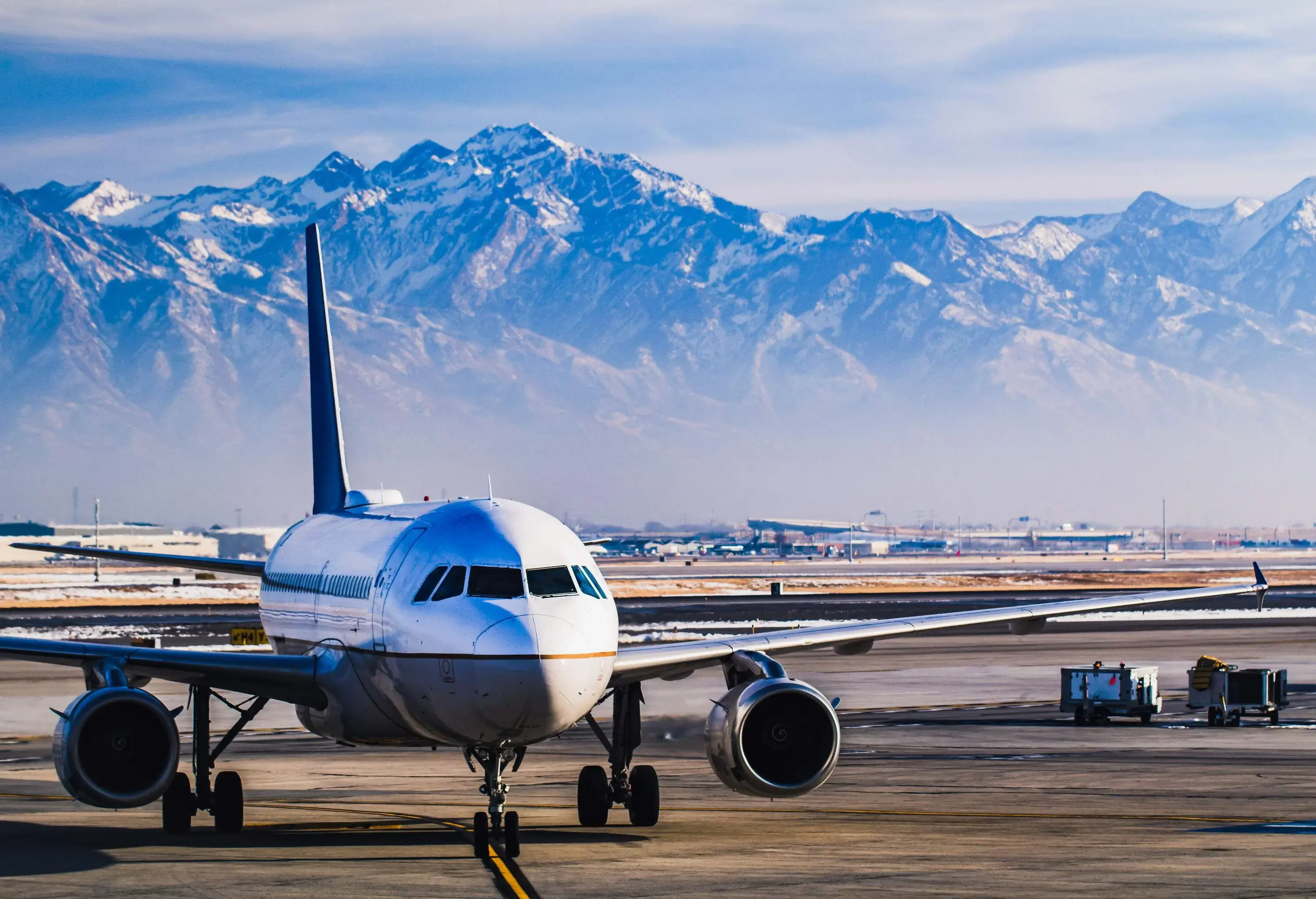An aeroplane in the flight line with snow-covered mountains in the background.