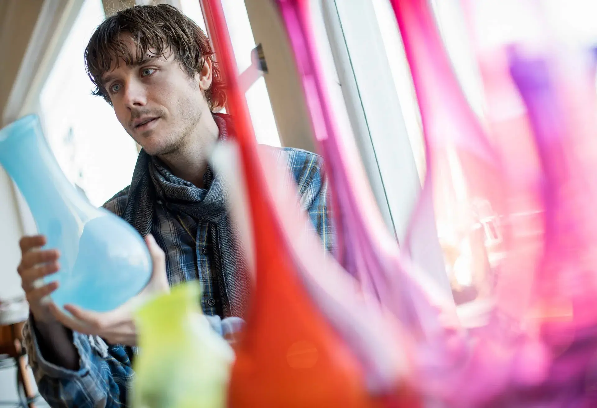 A man checking out a light blue bottle being sold in a store.