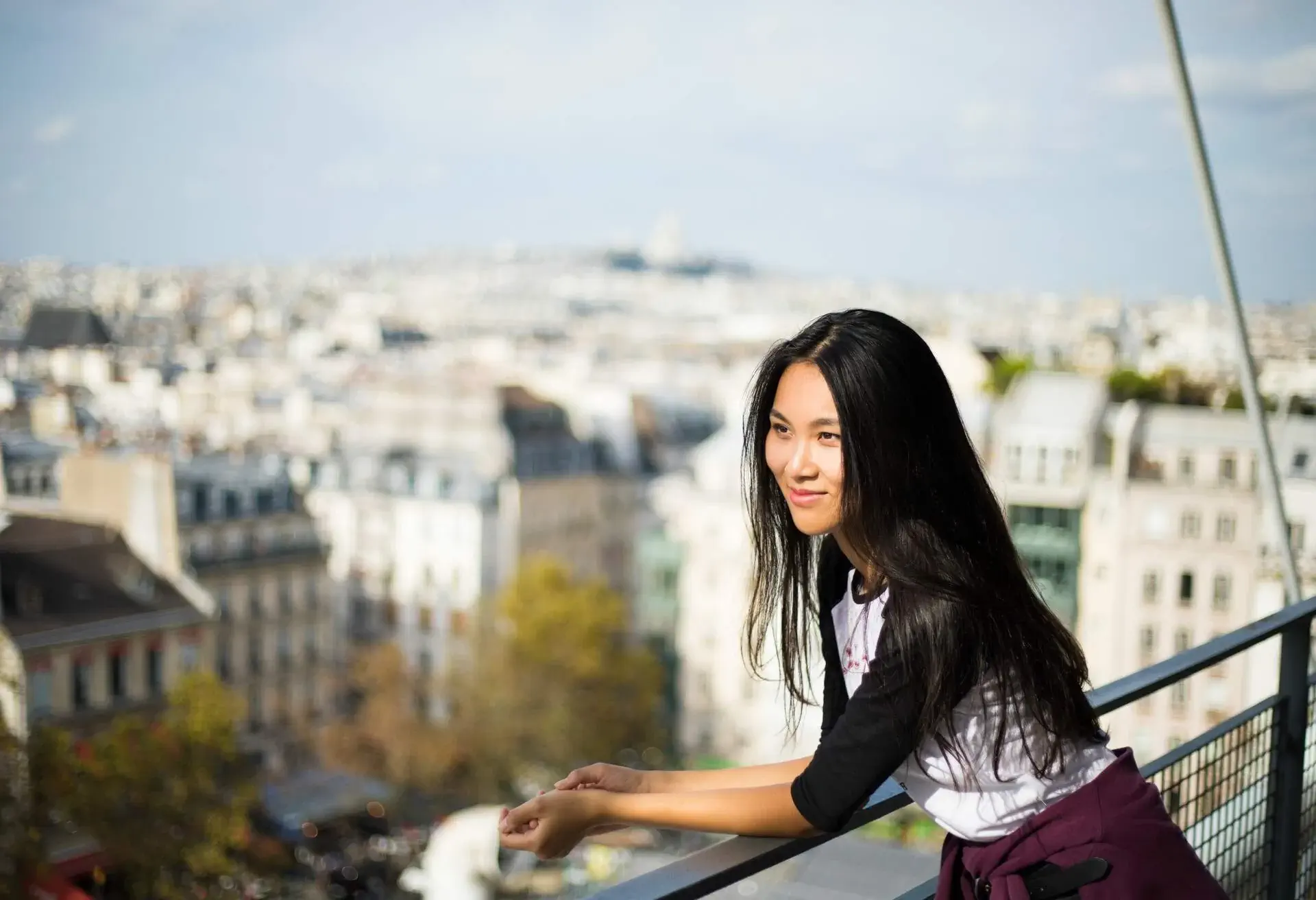 A long-haired woman smiles while leaning on a balcony, Centre Pompidou, Paris, France