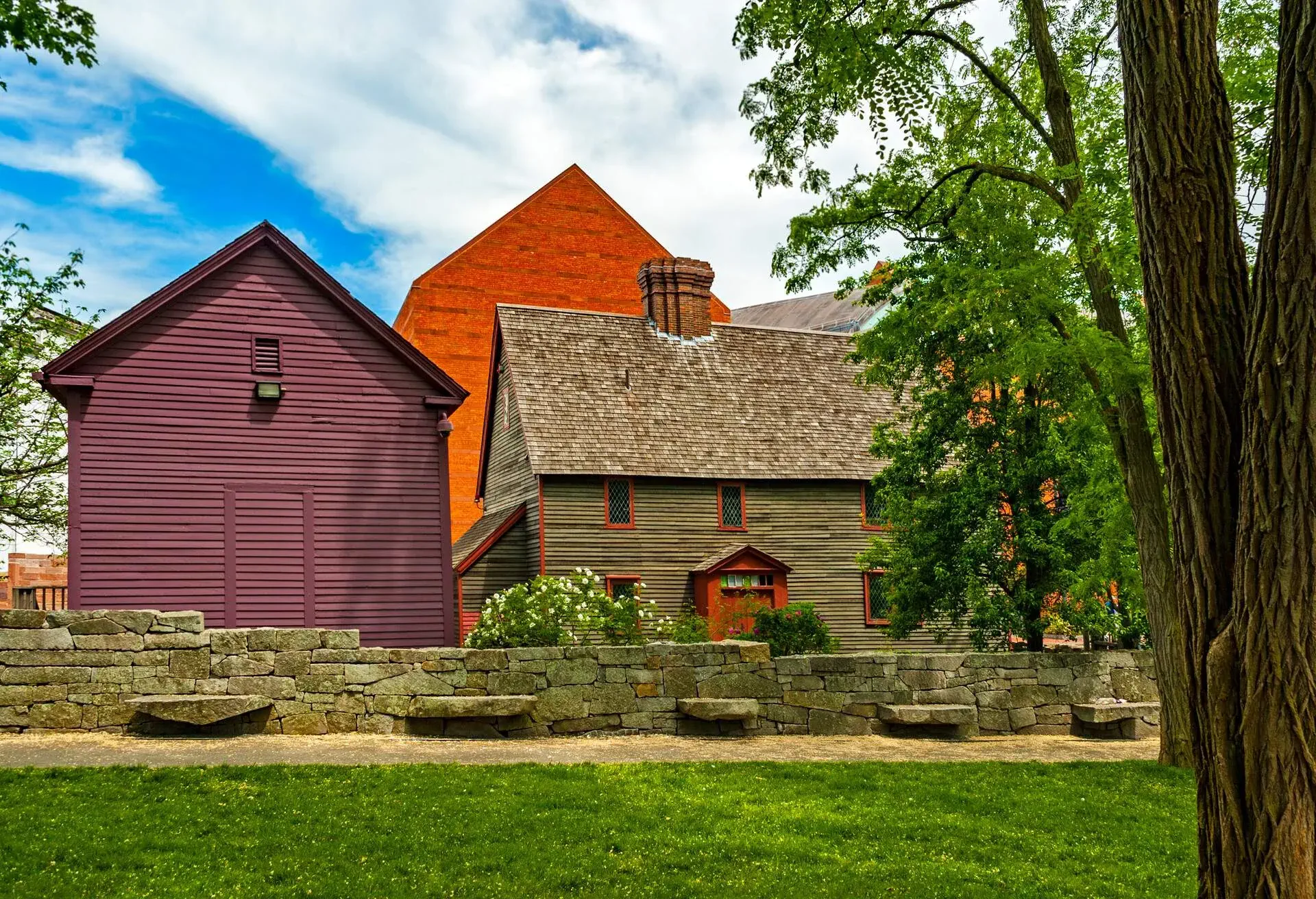 A cluster of gable-roofed wooden houses behind a low brick wall.