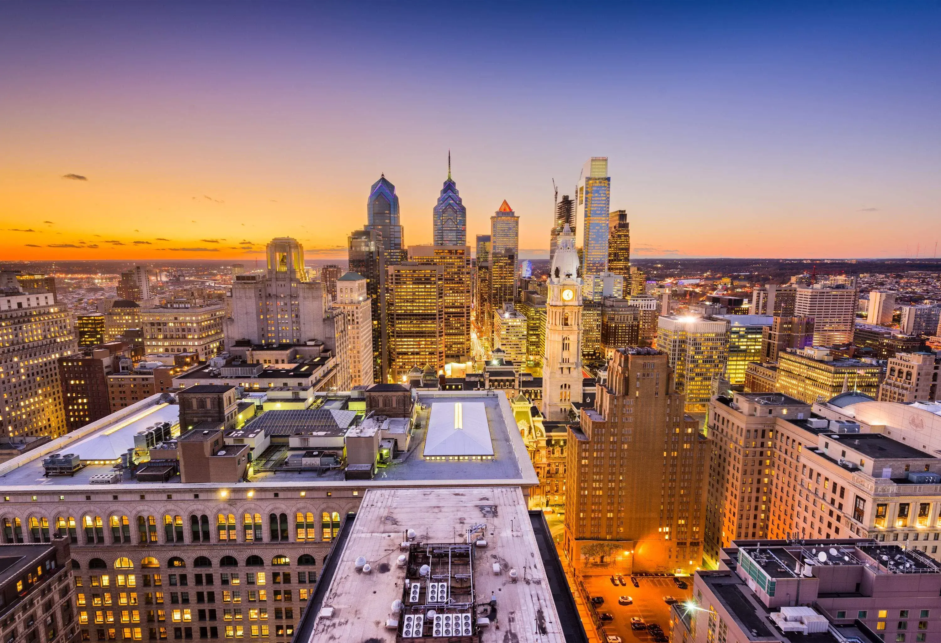 A remarkable skyline with lit skyscrapers jutting into the sky in vibrant yellow and blue hues.