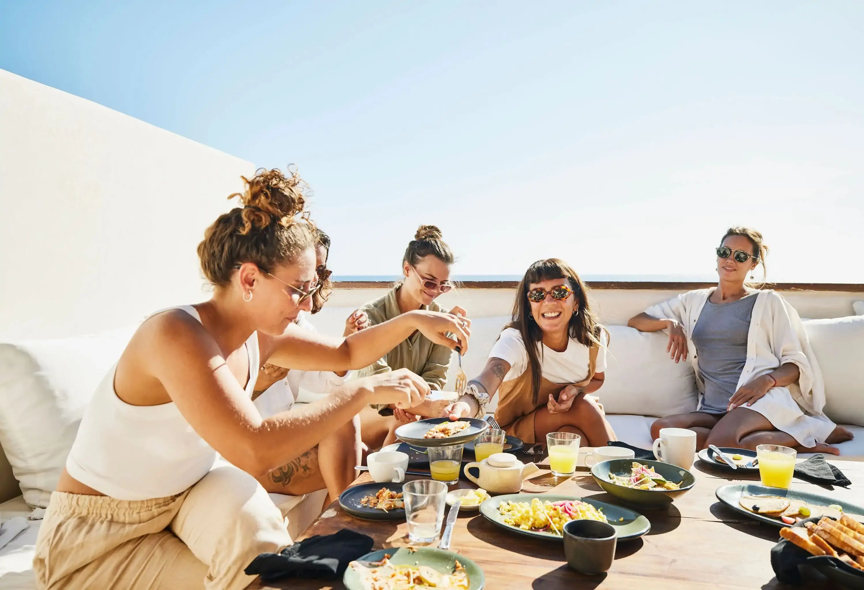 friends enjoying breakfast on a sunny terasse