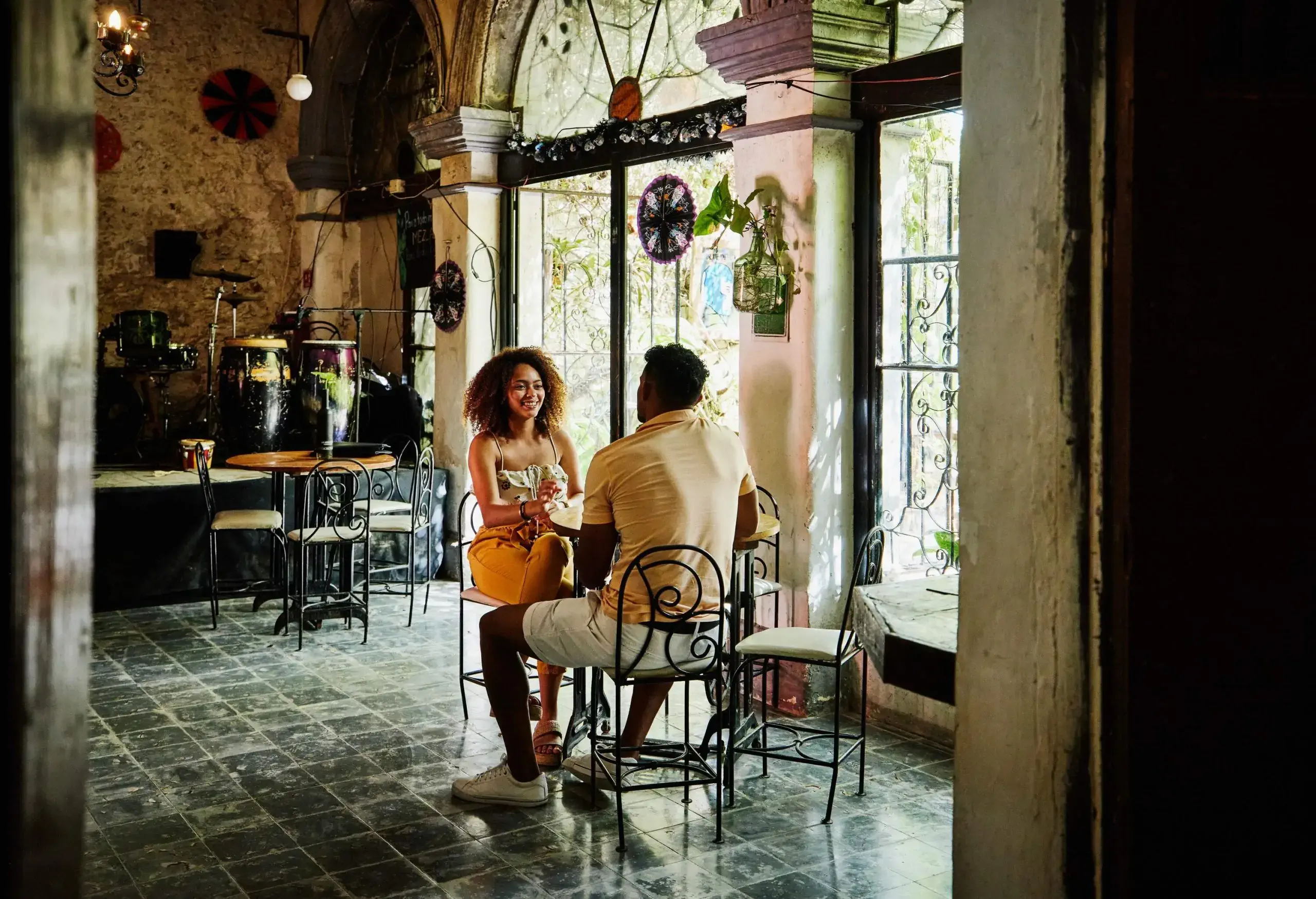A man and a woman engaged in a casual conversation while sitting inside a café. 