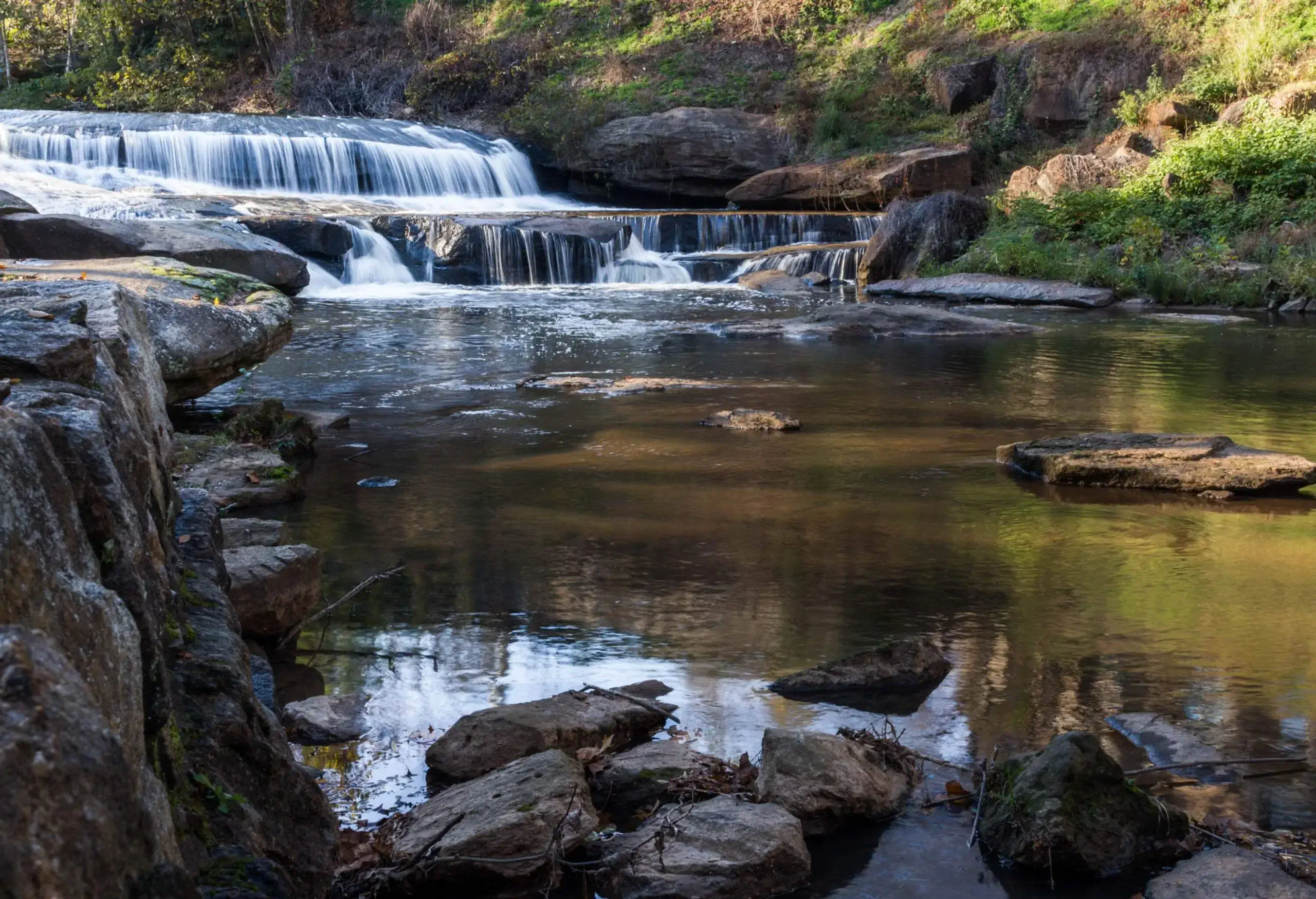 Water cascades down to a rocky stream.