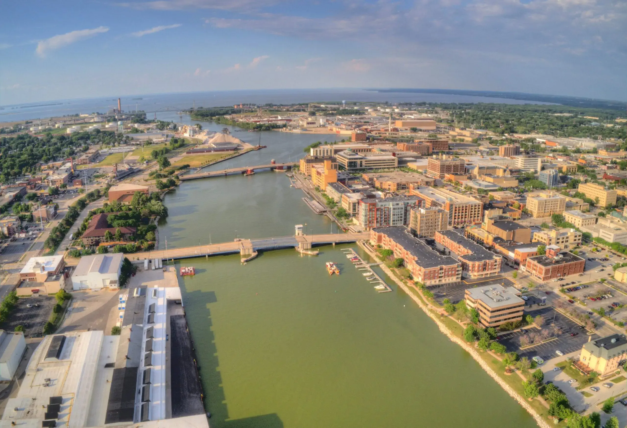 Aerial view of a green lake in the middle of an urban cityscape.